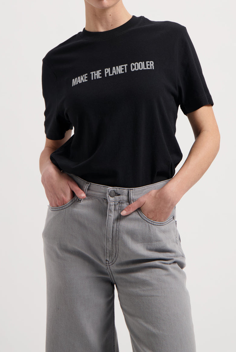 Sustainable MUD Jeans in classic black, made from organic cotton, paired with a white tee and casual white sneakers.