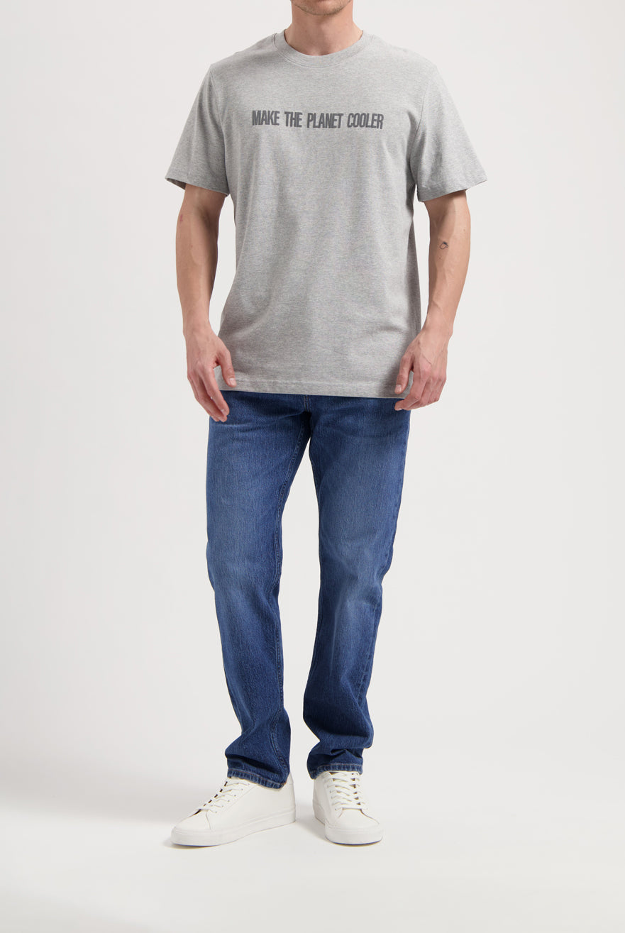 Sustainable MUD Jeans outfit, featuring blue denim jacket and jeans with slogan tees, promoting ethical fashion.