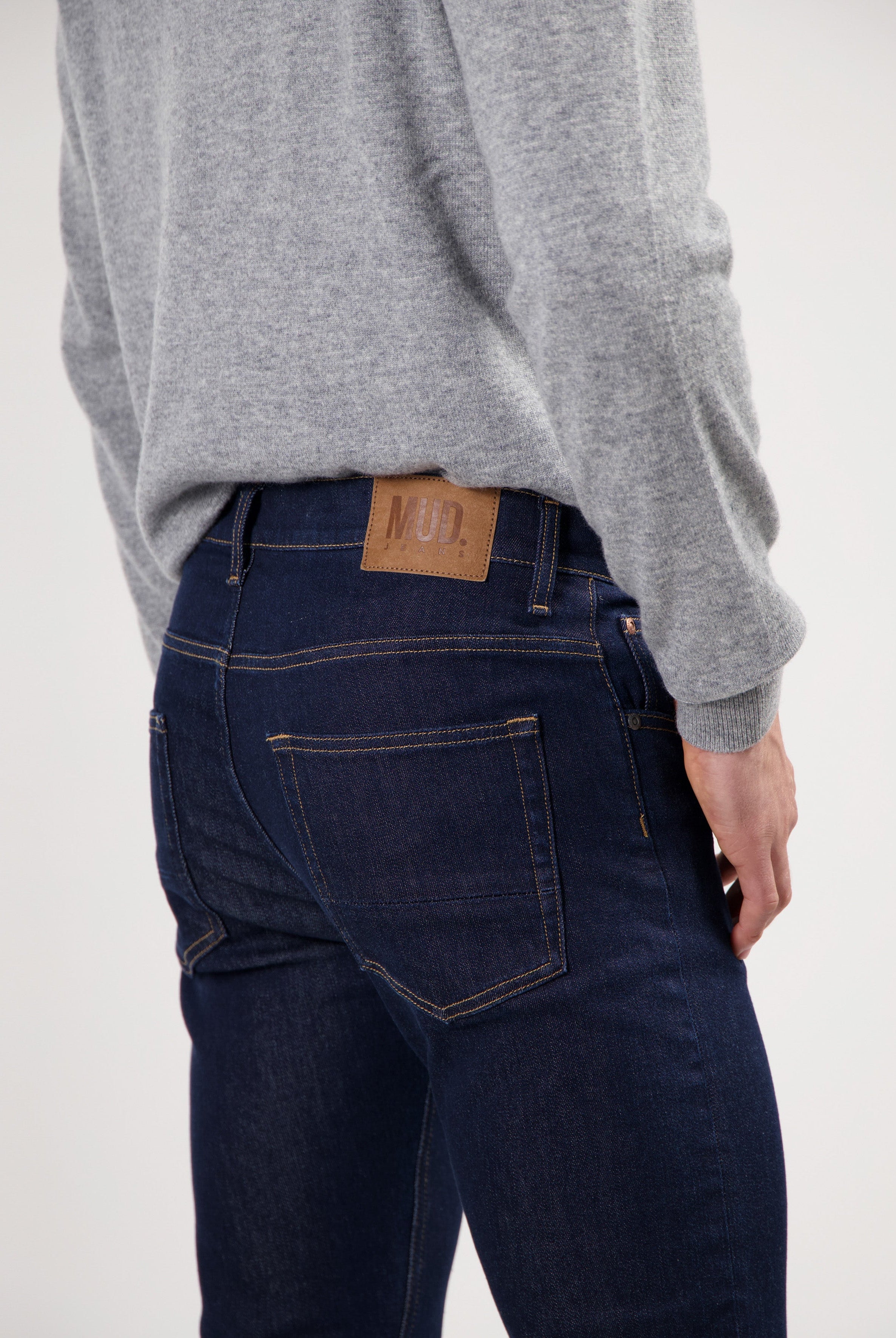 Sustainable MUD Jeans denim shorts in dark blue, showcasing ethical fashion, paired with white sneakers for a casual look.