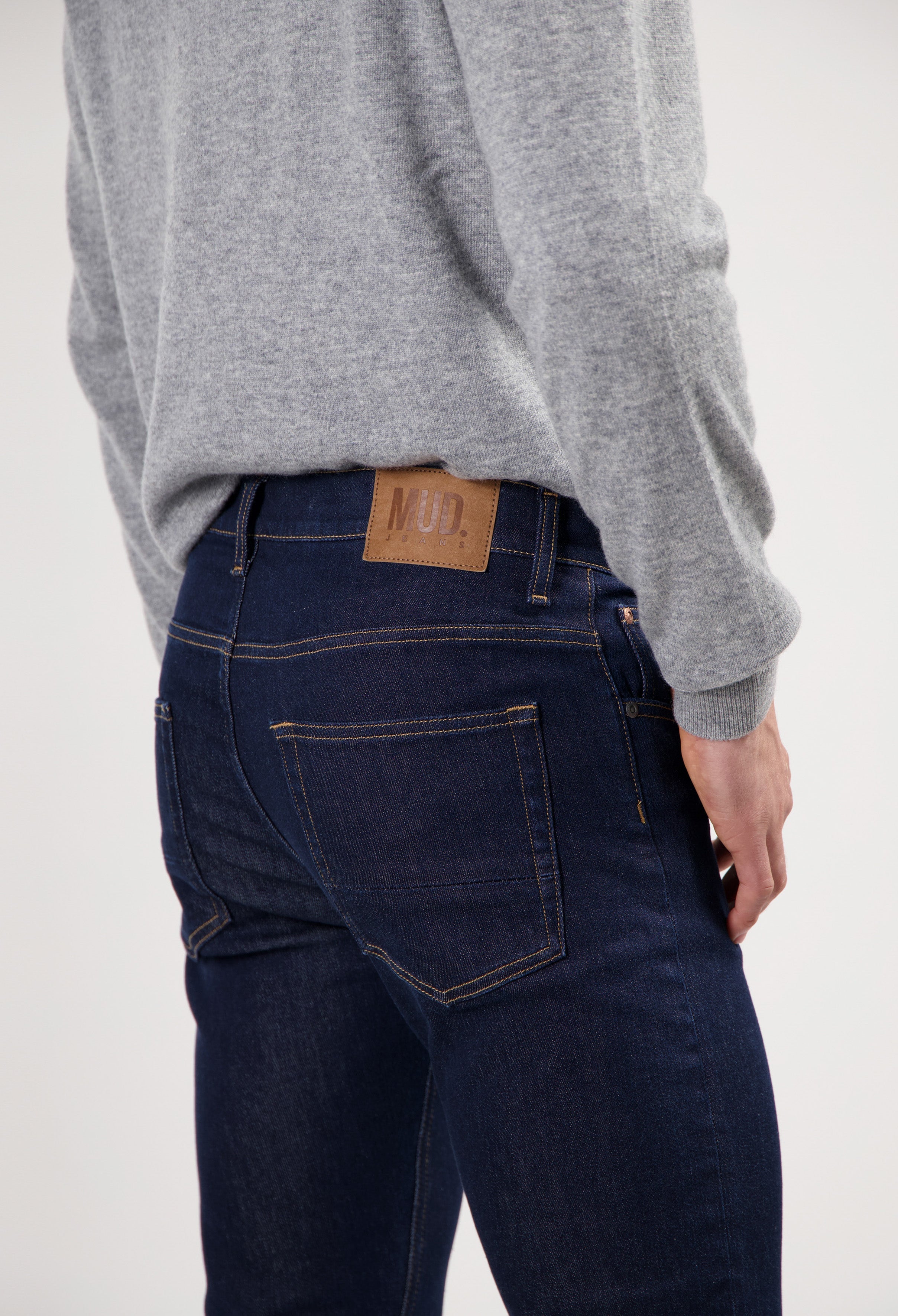 Sustainable MUD Jeans denim shorts in dark blue, showcasing ethical fashion, paired with white sneakers for a casual look.