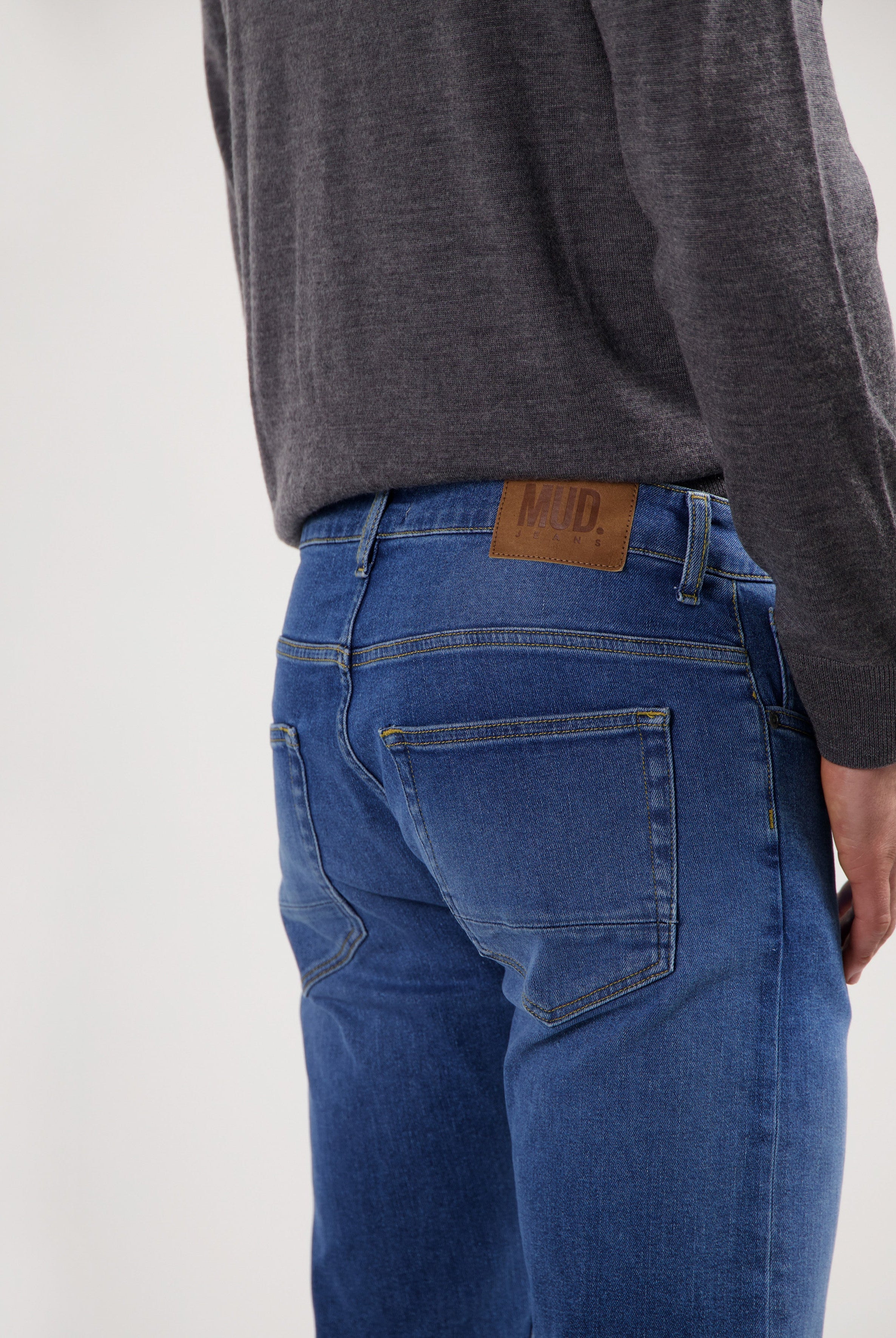 Sustainable MUD Jeans crafted from eco-friendly denim in dark blue, featuring a relaxed fit, paired with white sneakers.