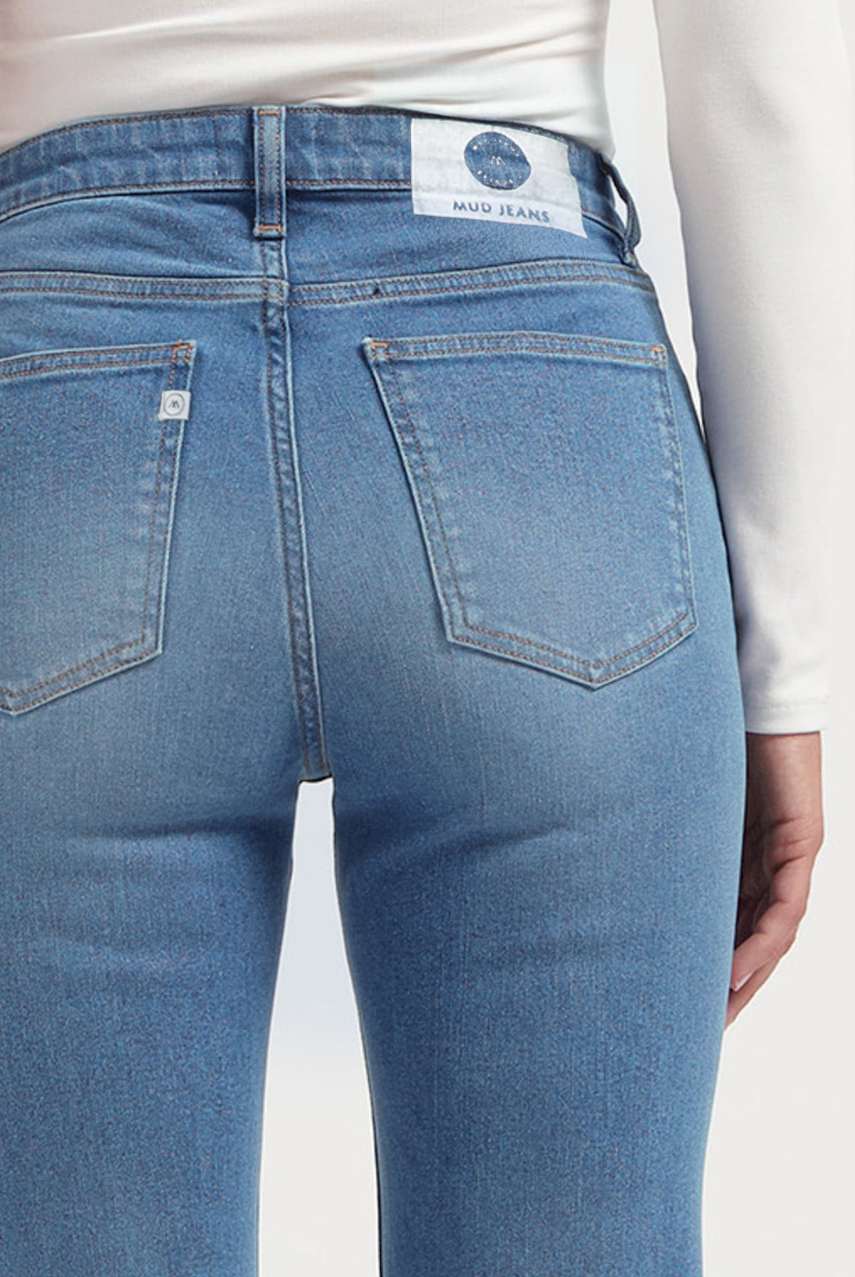 Back view of light blue sustainable MUD Jeans crafted from organic cotton, showcasing classic pocket stitching and white label.