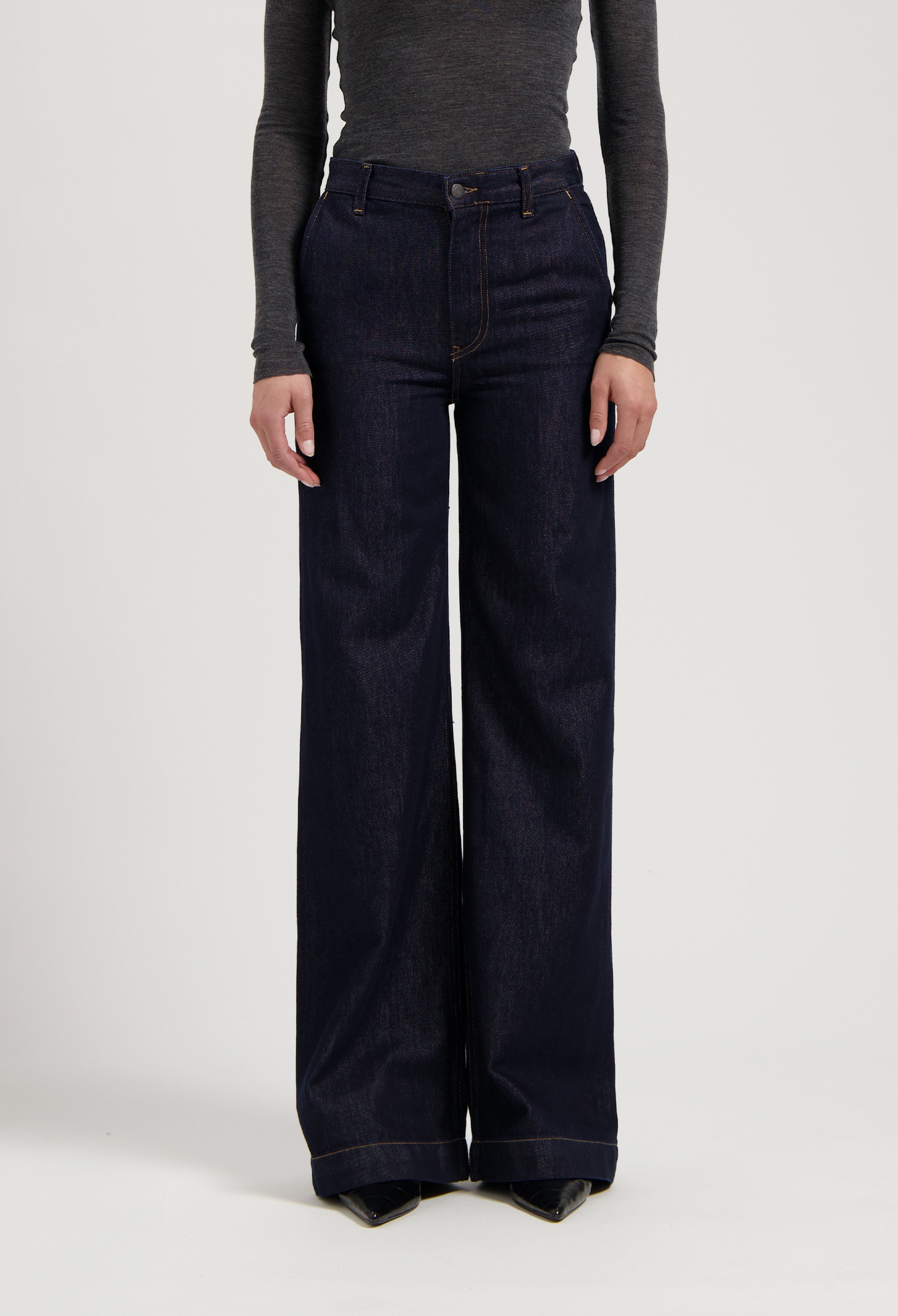 Dark indigo wide-leg jeans paired with a fitted long-sleeve gray top, highlighting a casual, stylish look.