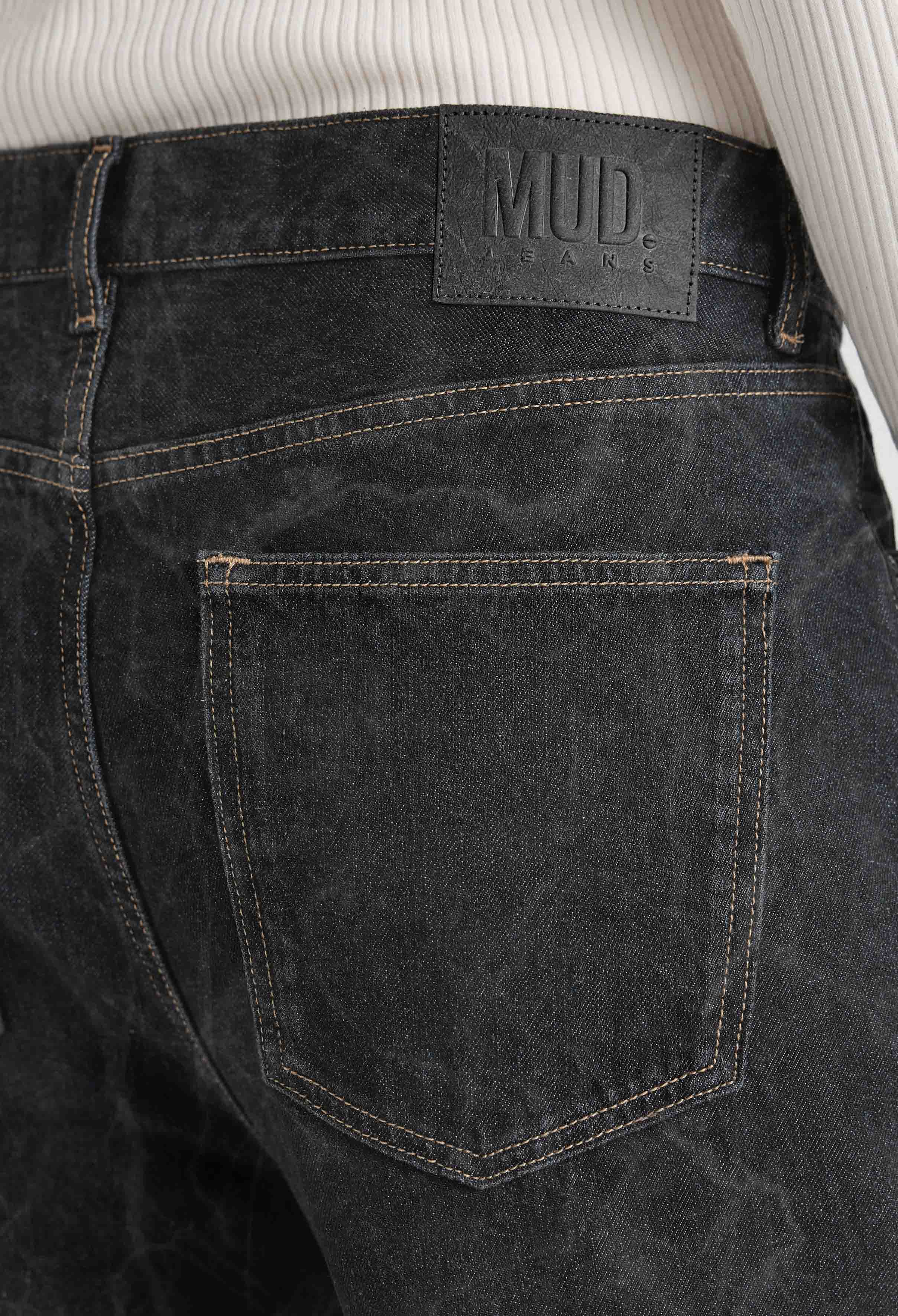 Back view of dark gray MUD Jeans made from organic cotton, highlighting sustainable material and leather logo patch.