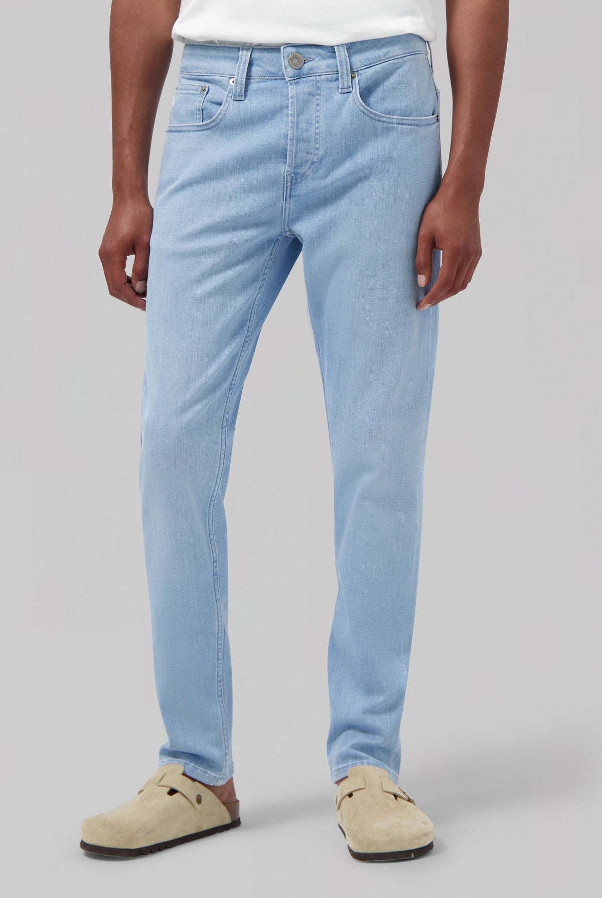 Sustainable MUD Jeans made from organic cotton, in classic blue, paired with a white shirt, showcasing ethical fashion.