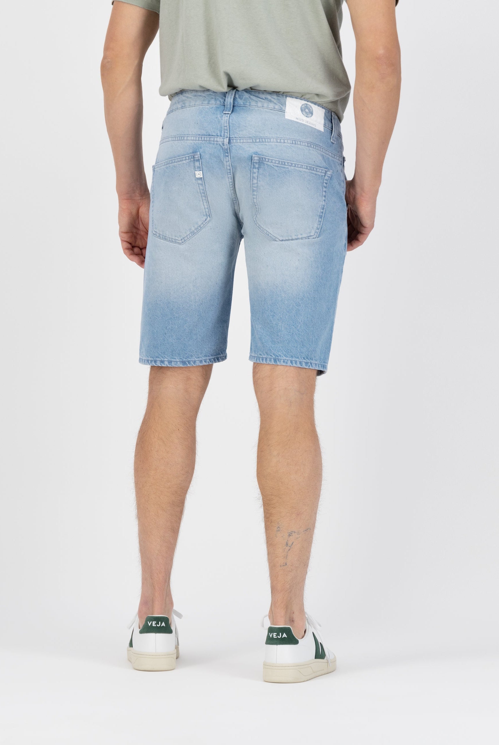 Sustainable MUD Jeans in light blue denim, showcasing ethical fashion with organic cotton, worn with a black sweater.