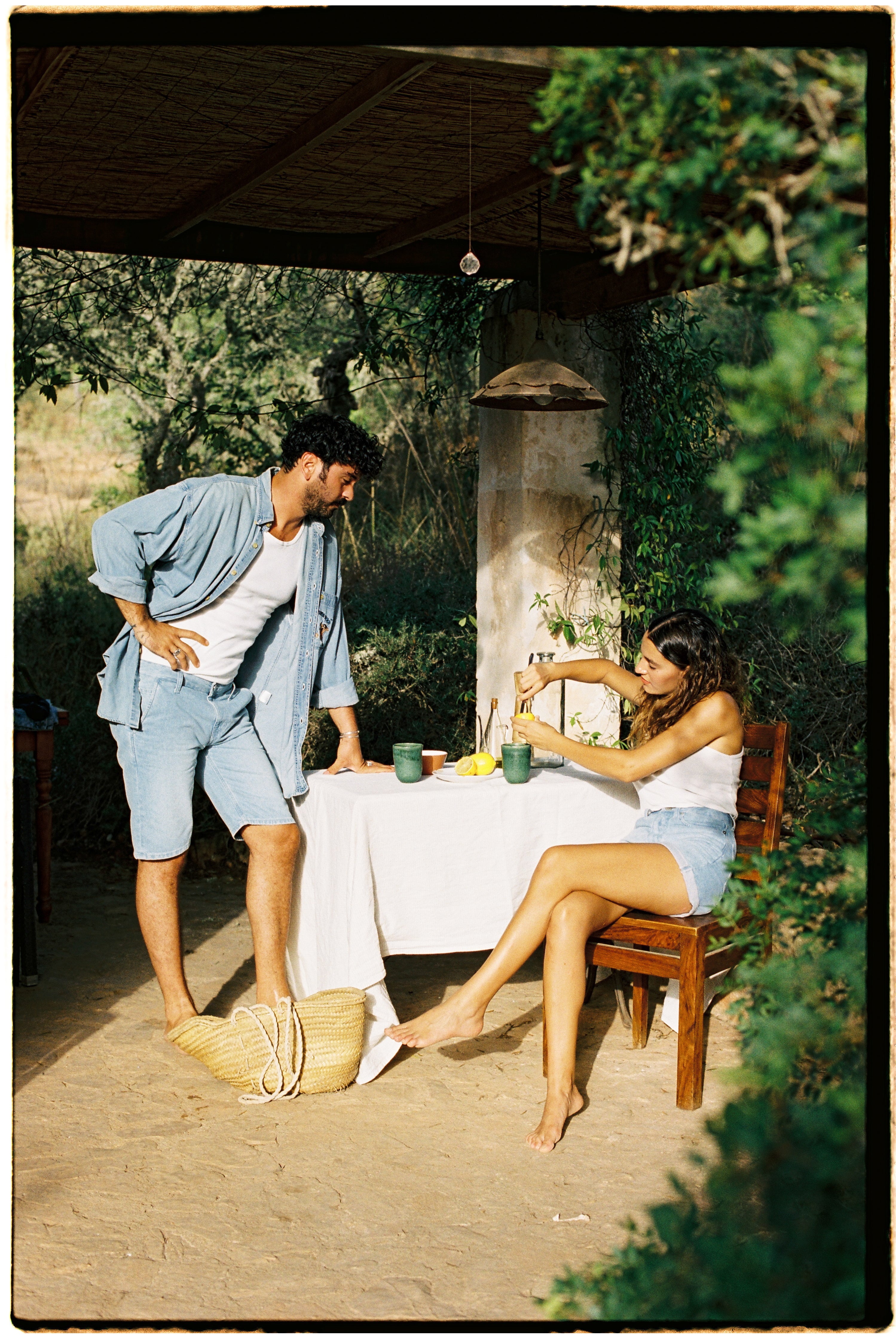 Sustainable MUD Jeans in mid-blue denim, crafted from organic cotton, worn with a black sweater and white sneakers.