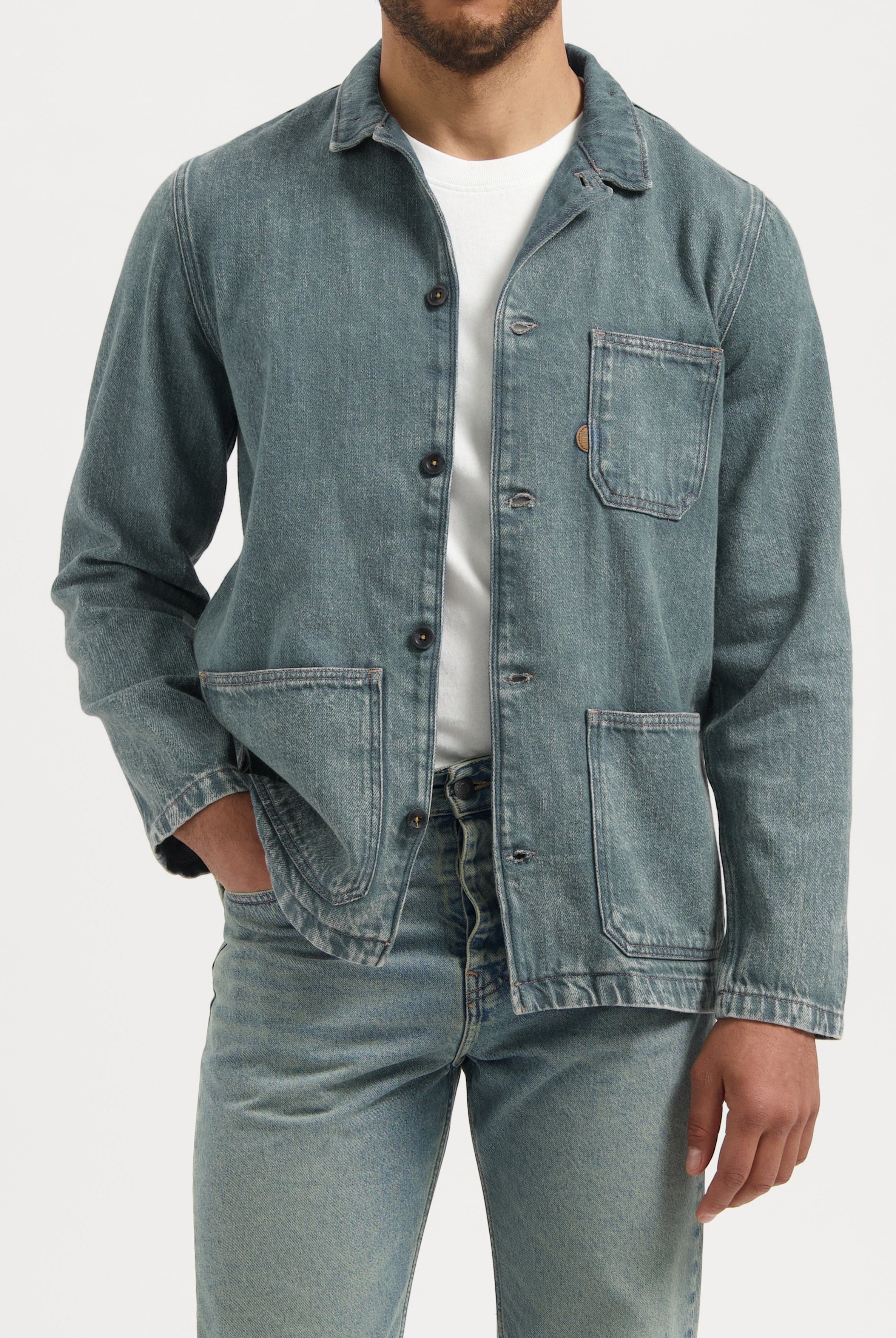 Sustainable MUD Jeans featuring light blue denim, emphasizing ethical fashion, paired with a gray T-shirt.