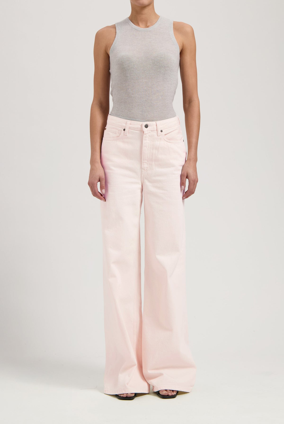 Wide-leg pale pink jeans paired with a form-fitting light gray sleeveless top, showcasing casual chic style.