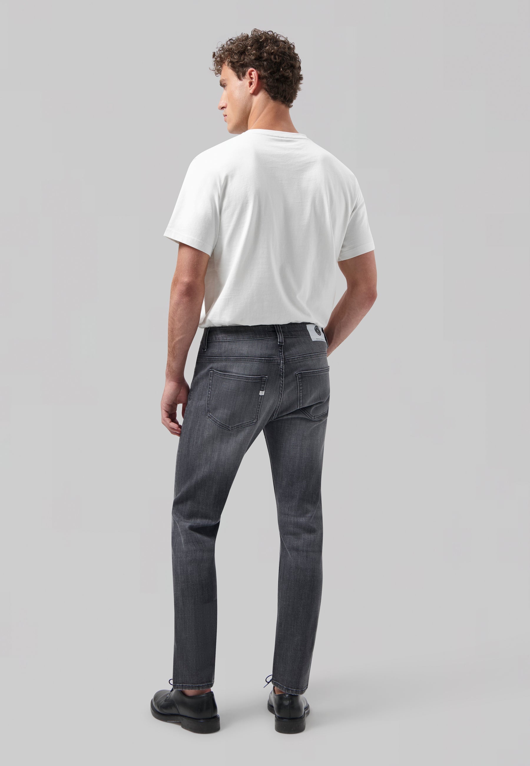 Sustainable MUD Jeans in light blue denim, featuring ethical materials and a straight fit, paired with a white T-shirt.