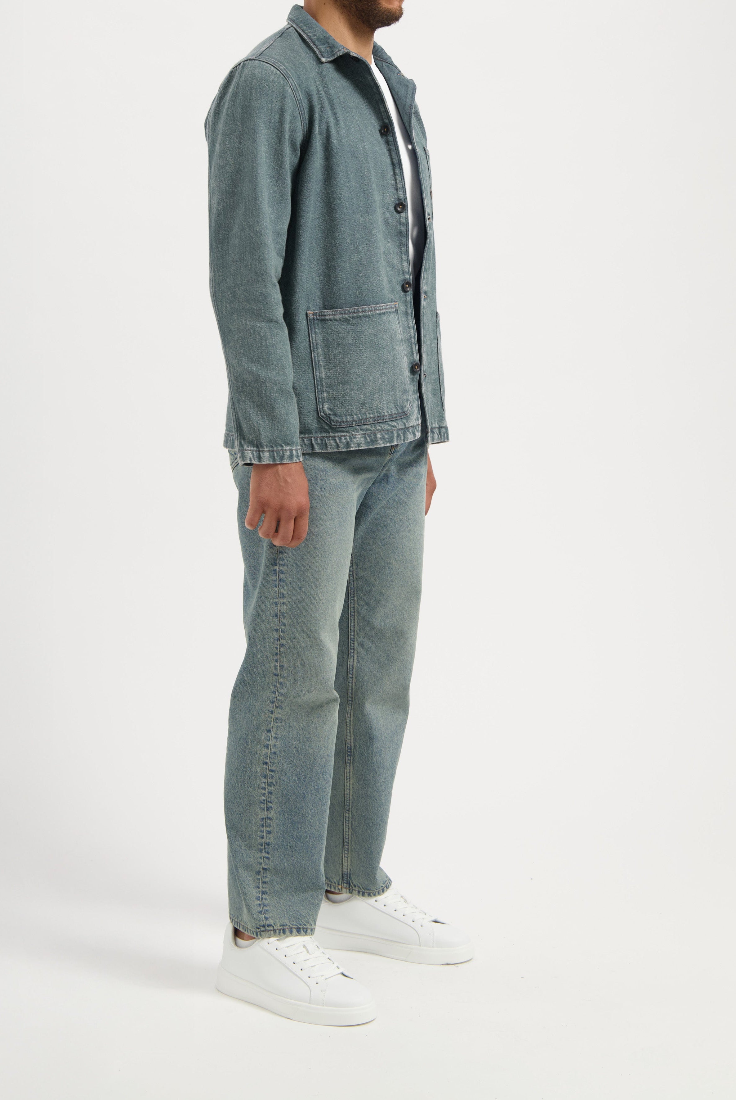 Sustainable MUD Jeans made from organic cotton, featuring mid-blue denim in a slim fit, paired with a white t-shirt.