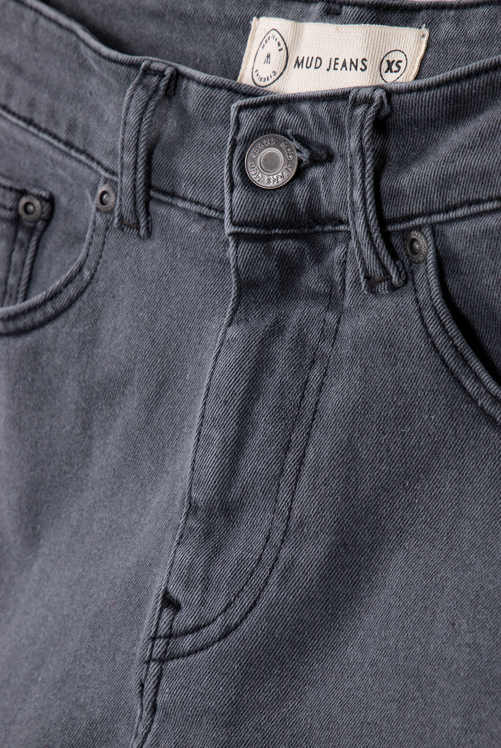 Close-up of organic cotton MUD Jeans in dark gray, showcasing premium denim texture and detailed stitching.