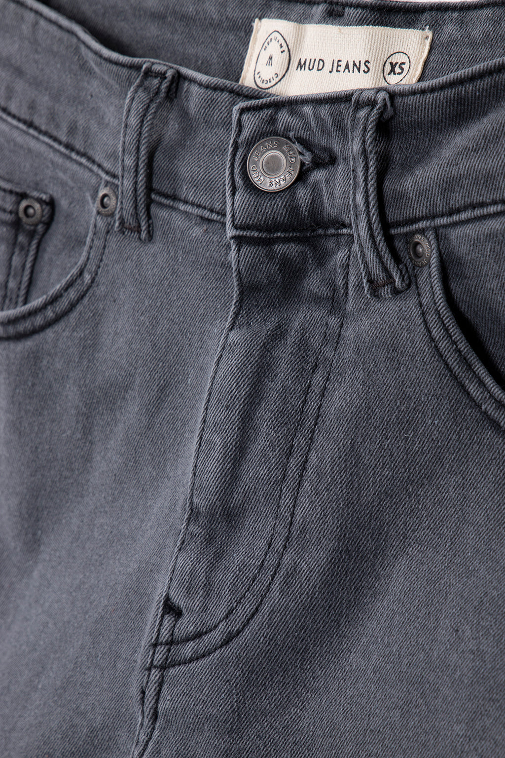 Close-up of organic cotton MUD Jeans in dark gray, showcasing premium denim texture and detailed stitching.