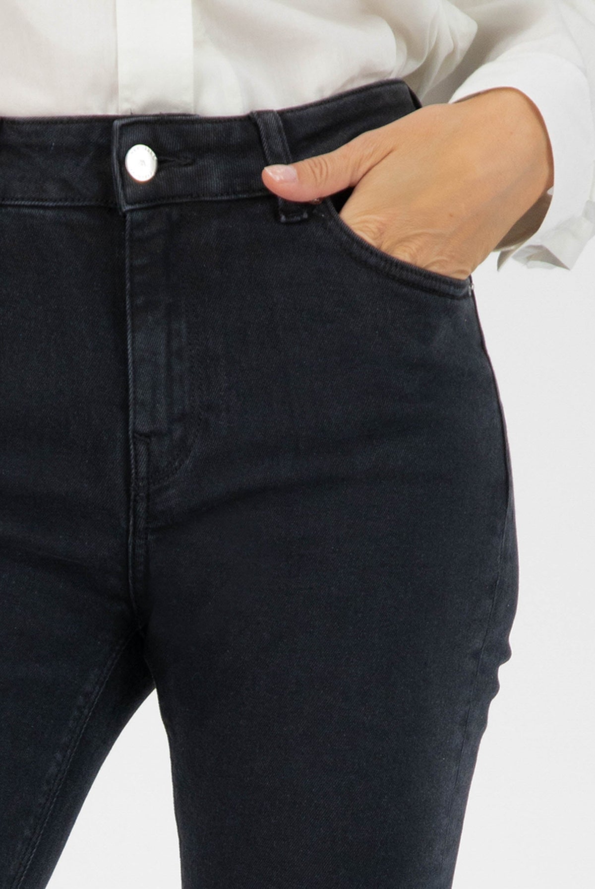 Stylish black denim jeans in a slim-fit design, demonstrated with hand in pocket, paired with a classic white shirt.
