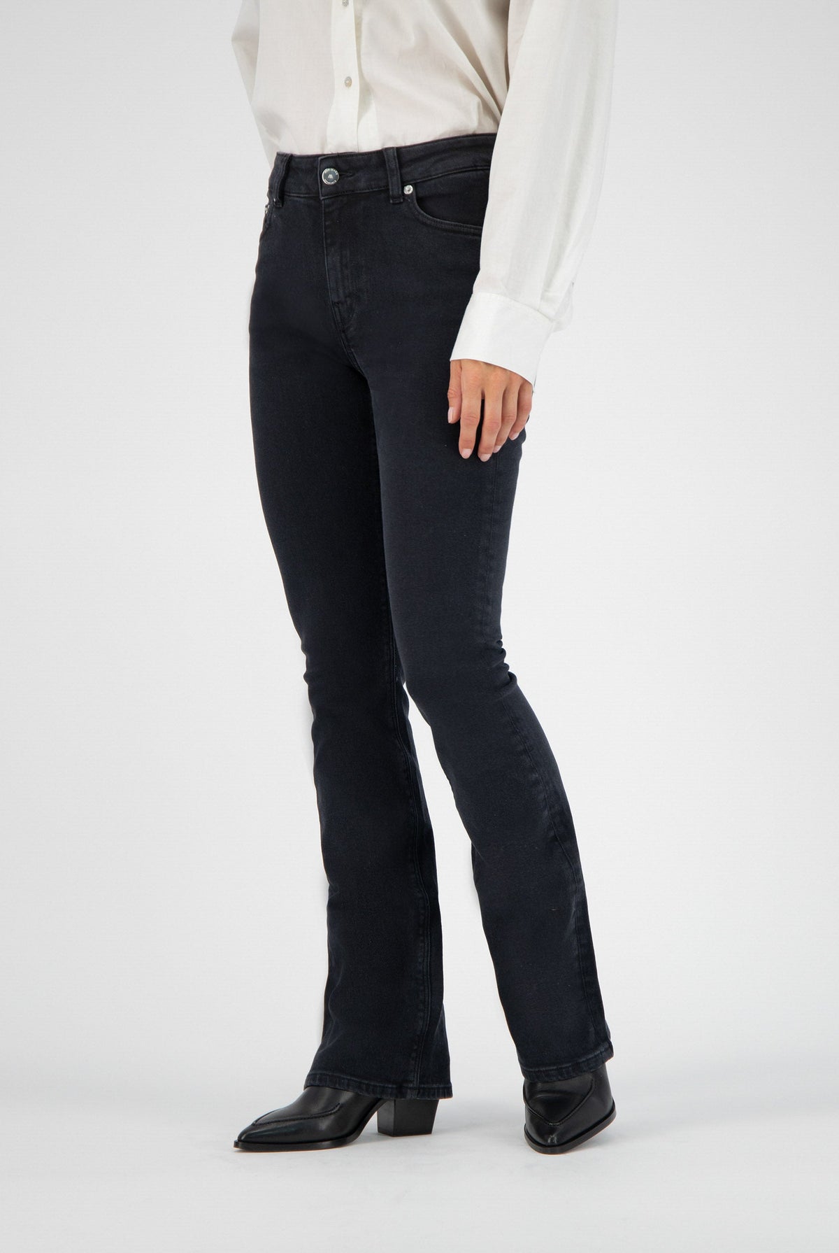 Black flared denim jeans paired with a classic white button-up shirt and black leather ankle boots.