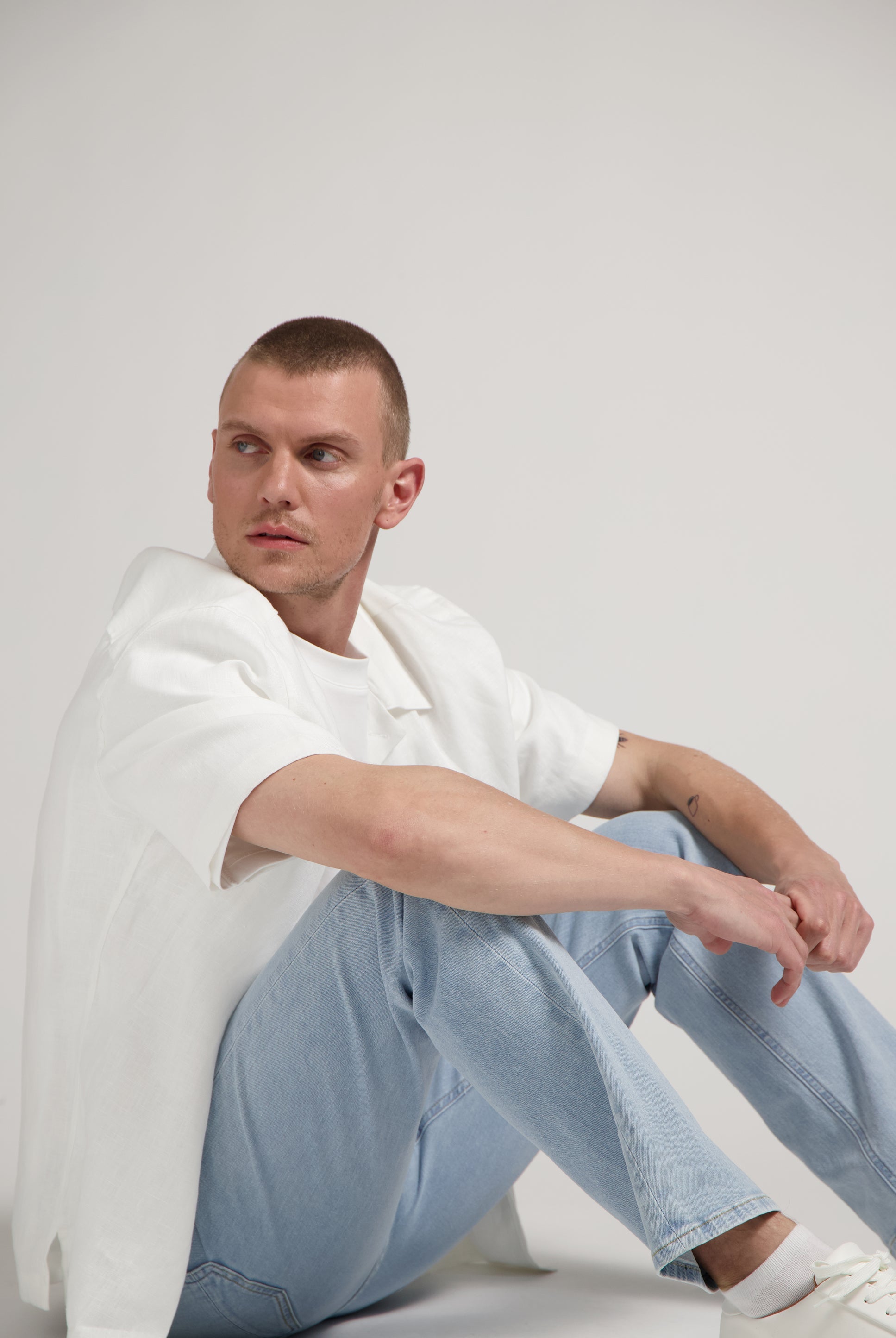 Sustainable MUD Jeans in deep blue denim, crafted ethically from organic cotton, paired with a casual white T-shirt.