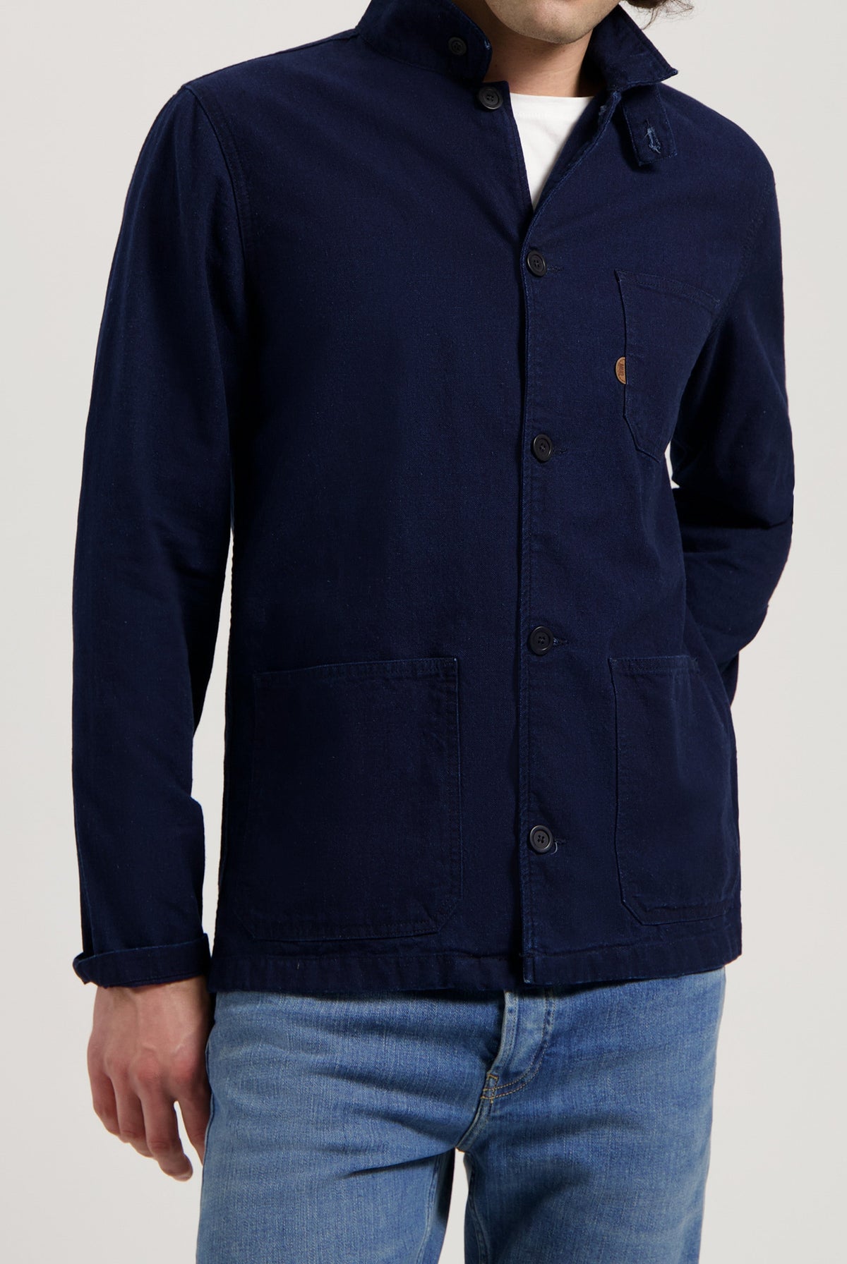 Sustainable MUD Jeans in blue denim, crafted from organic cotton, paired with a cozy cream sweater.