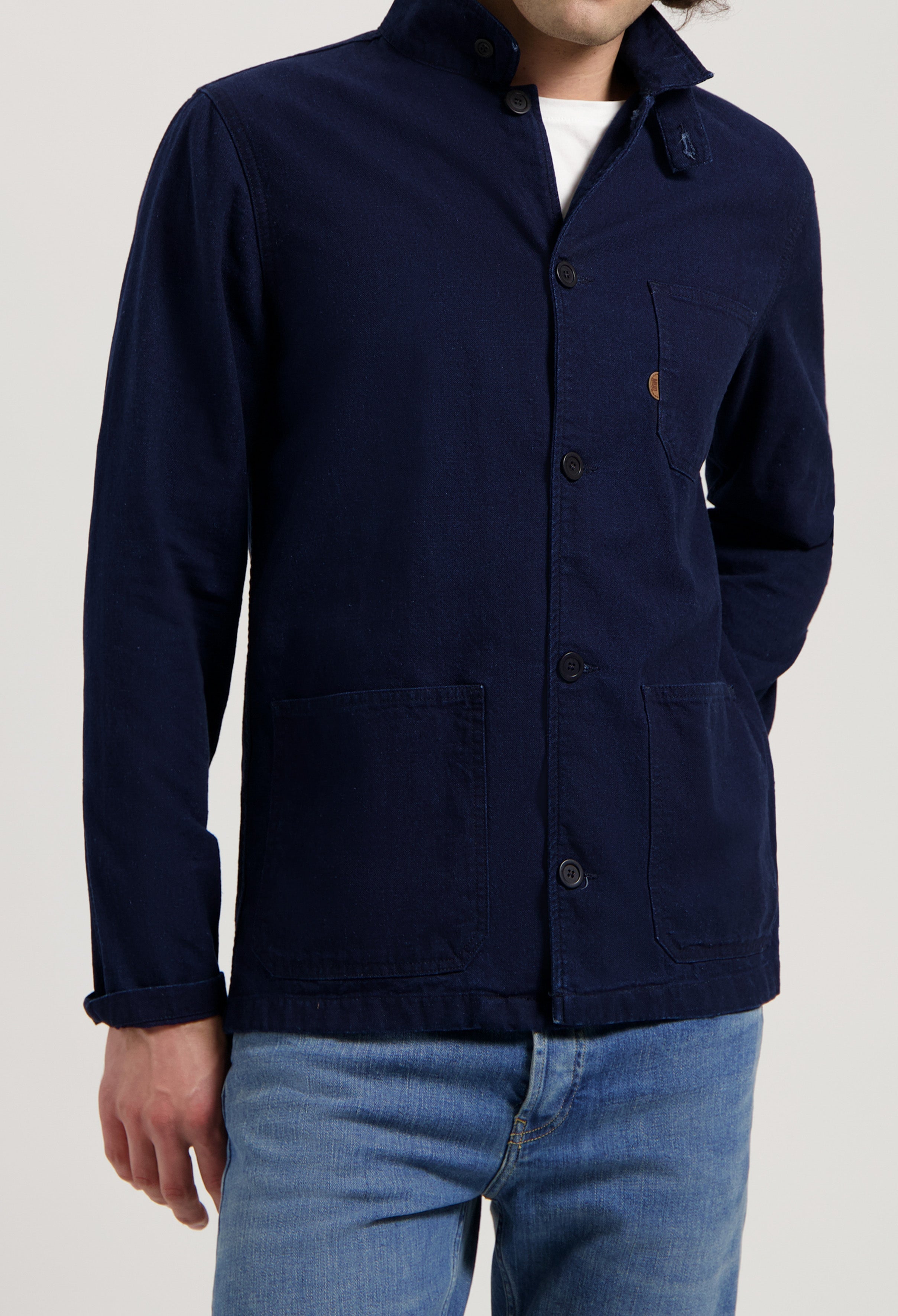 Sustainable MUD Jeans in blue denim, crafted from organic cotton, paired with a cozy cream sweater.