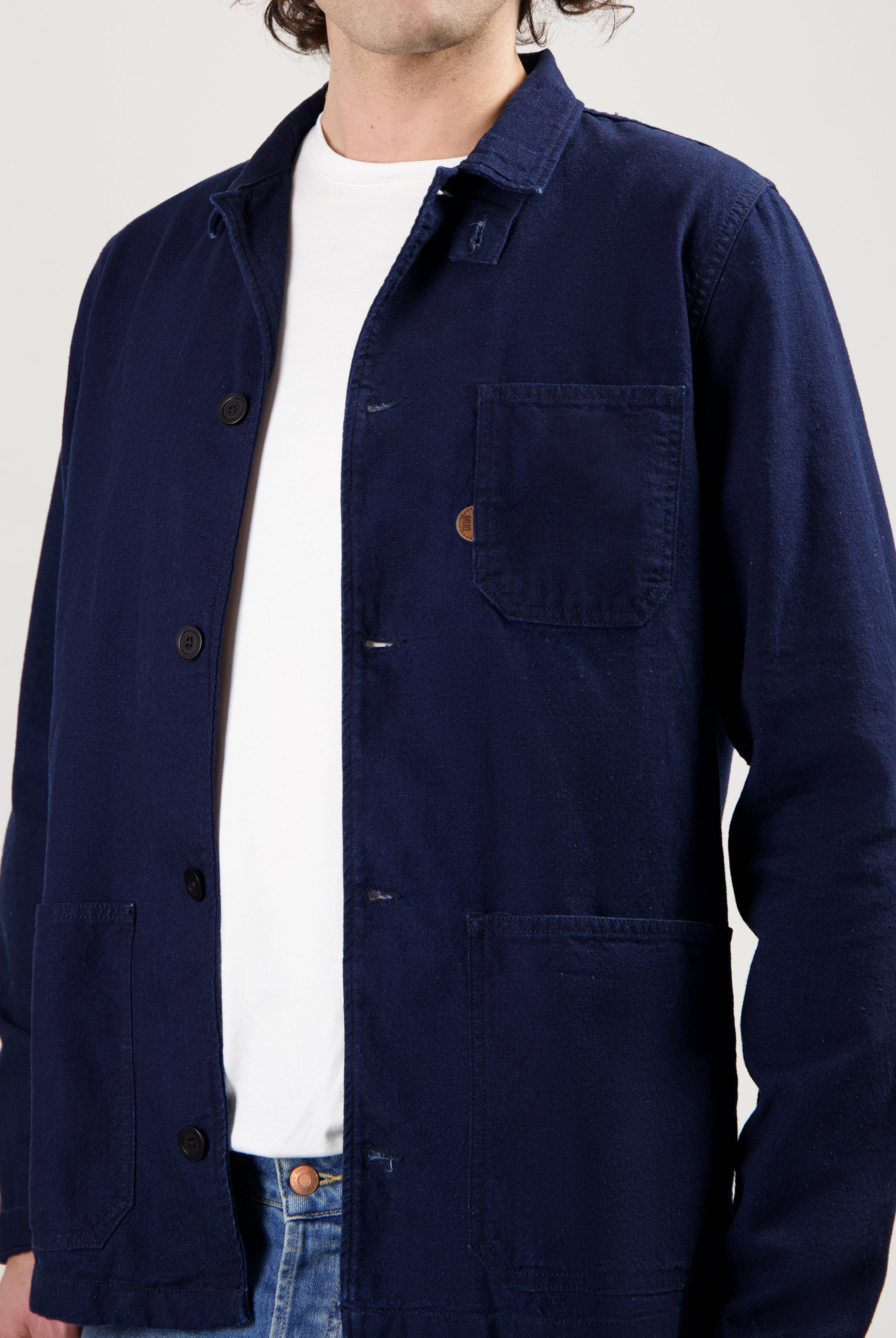 Sustainable MUD Jeans in classic blue, crafted from ethical materials, paired with a simple white tee and sneakers.