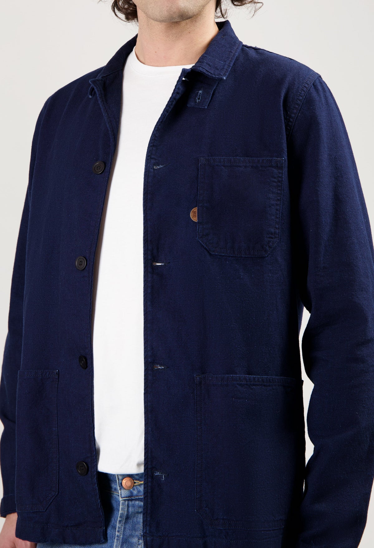 Sustainable MUD Jeans in classic blue, crafted from ethical materials, paired with a simple white tee and sneakers.
