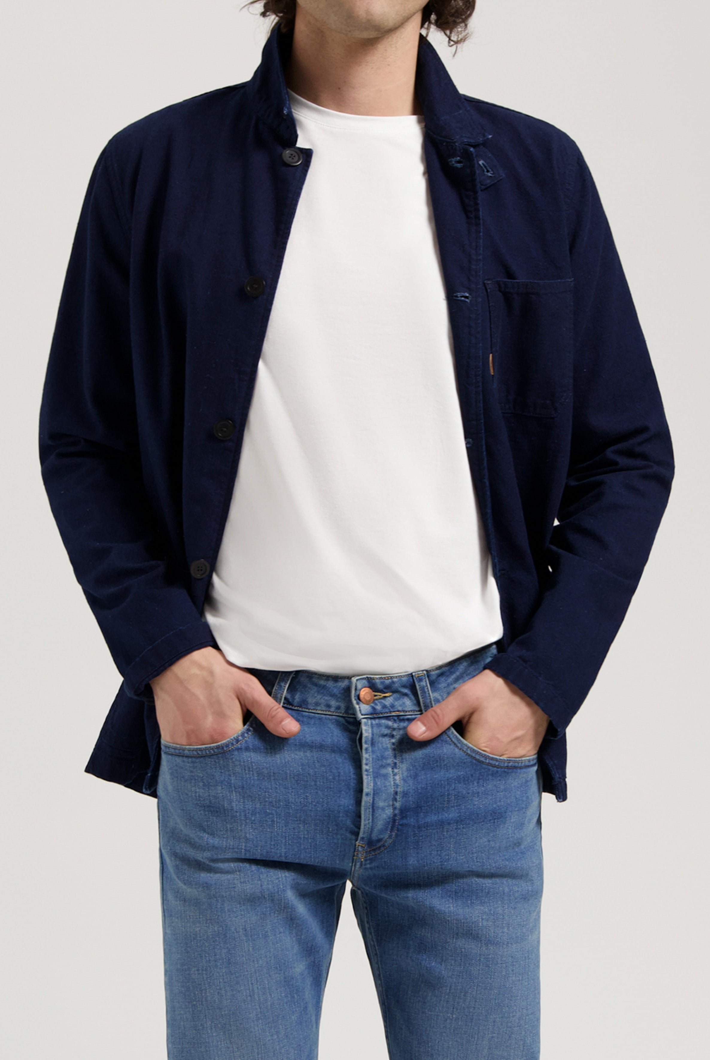 Sustainable MUD Jeans made from organic cotton, classic blue denim paired with a white tee and sneakers.