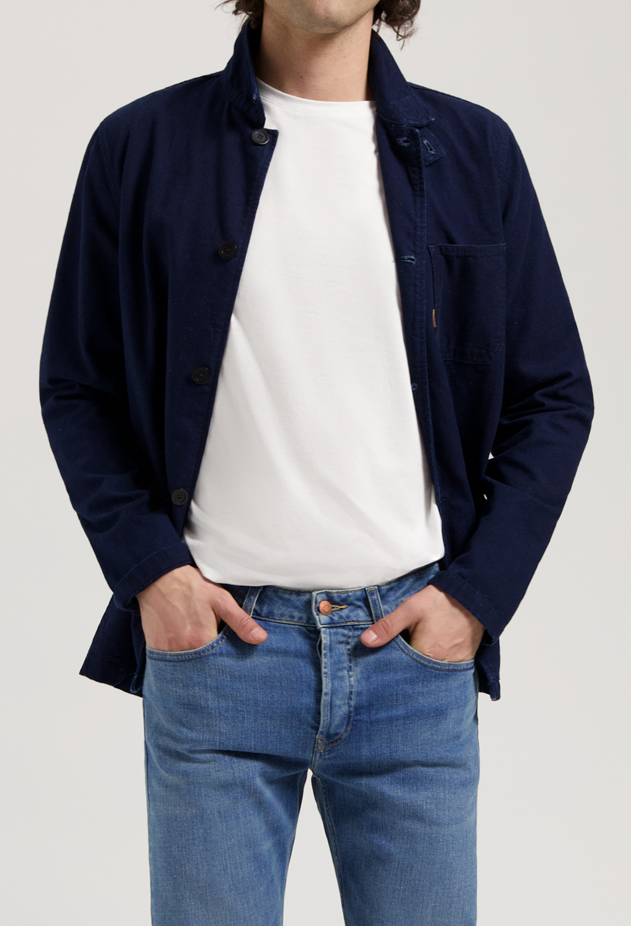 Sustainable MUD Jeans made from organic cotton, classic blue denim paired with a white tee and sneakers.