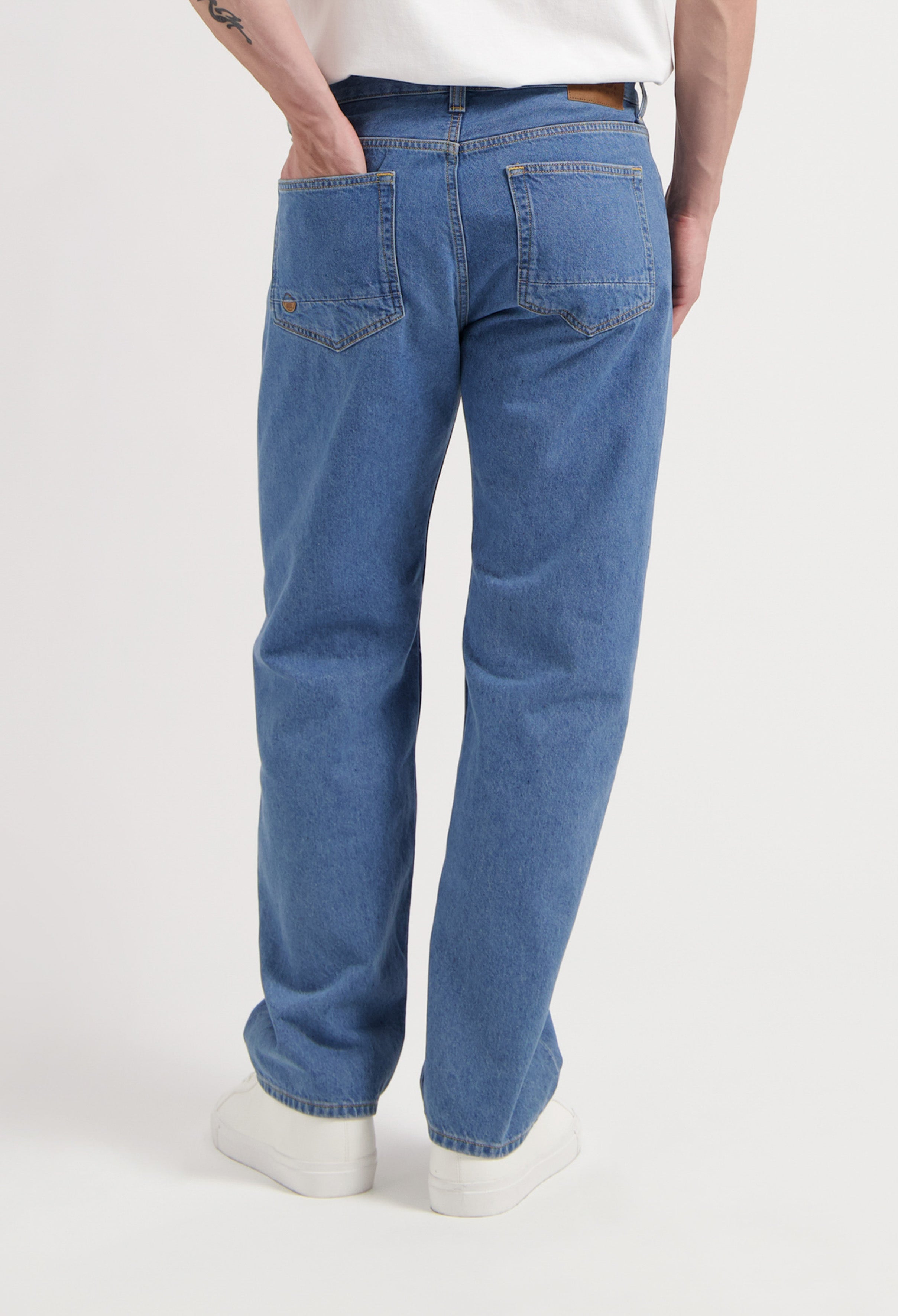 Sustainable Mud Jeans crafted from organic cotton in light blue denim, highlighting ethical fashion, paired with black shoes.