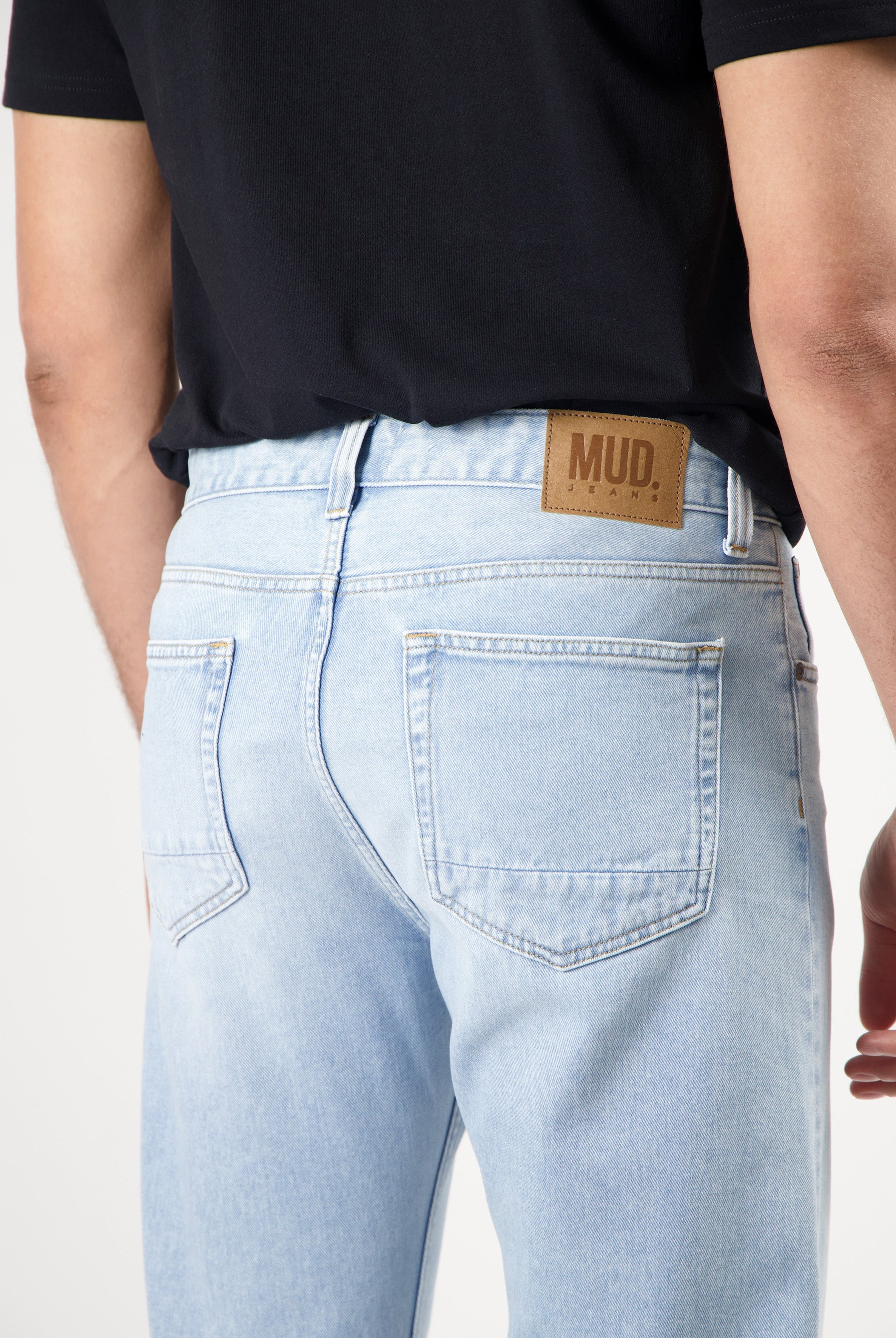 Sustainable MUD Jeans in dark blue denim, featuring classic stitching and ethical design, view of back pocket detail.