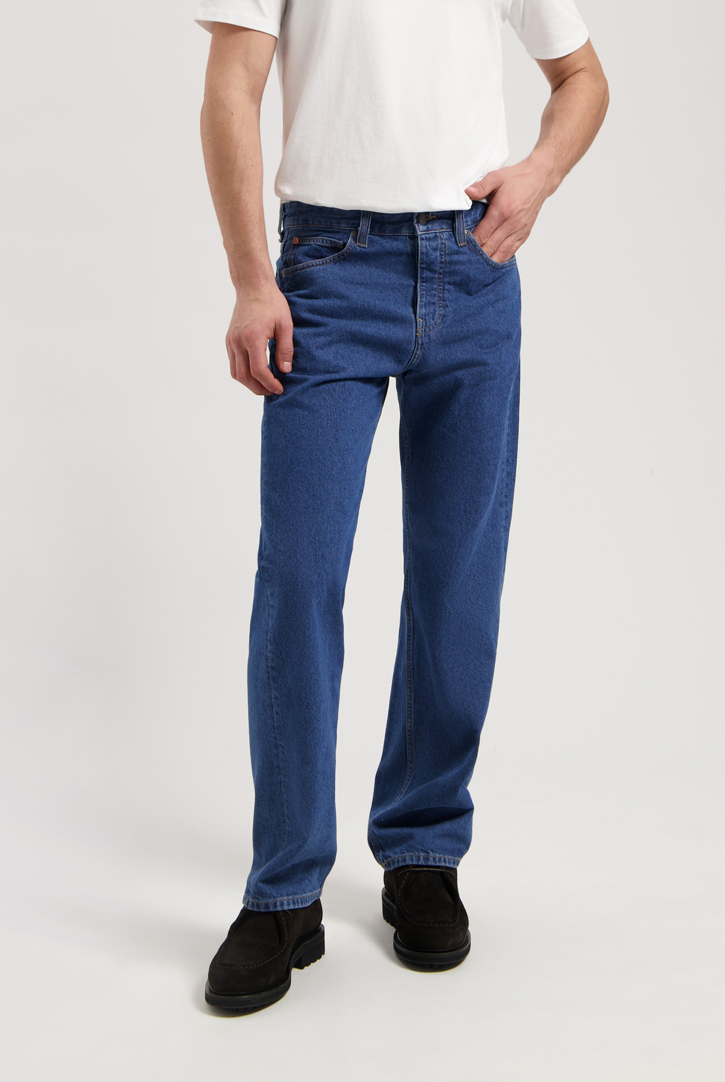 Sustainable MUD Jeans in dark gray denim, crafted ethically for a slim fit, paired with black dress shoes.