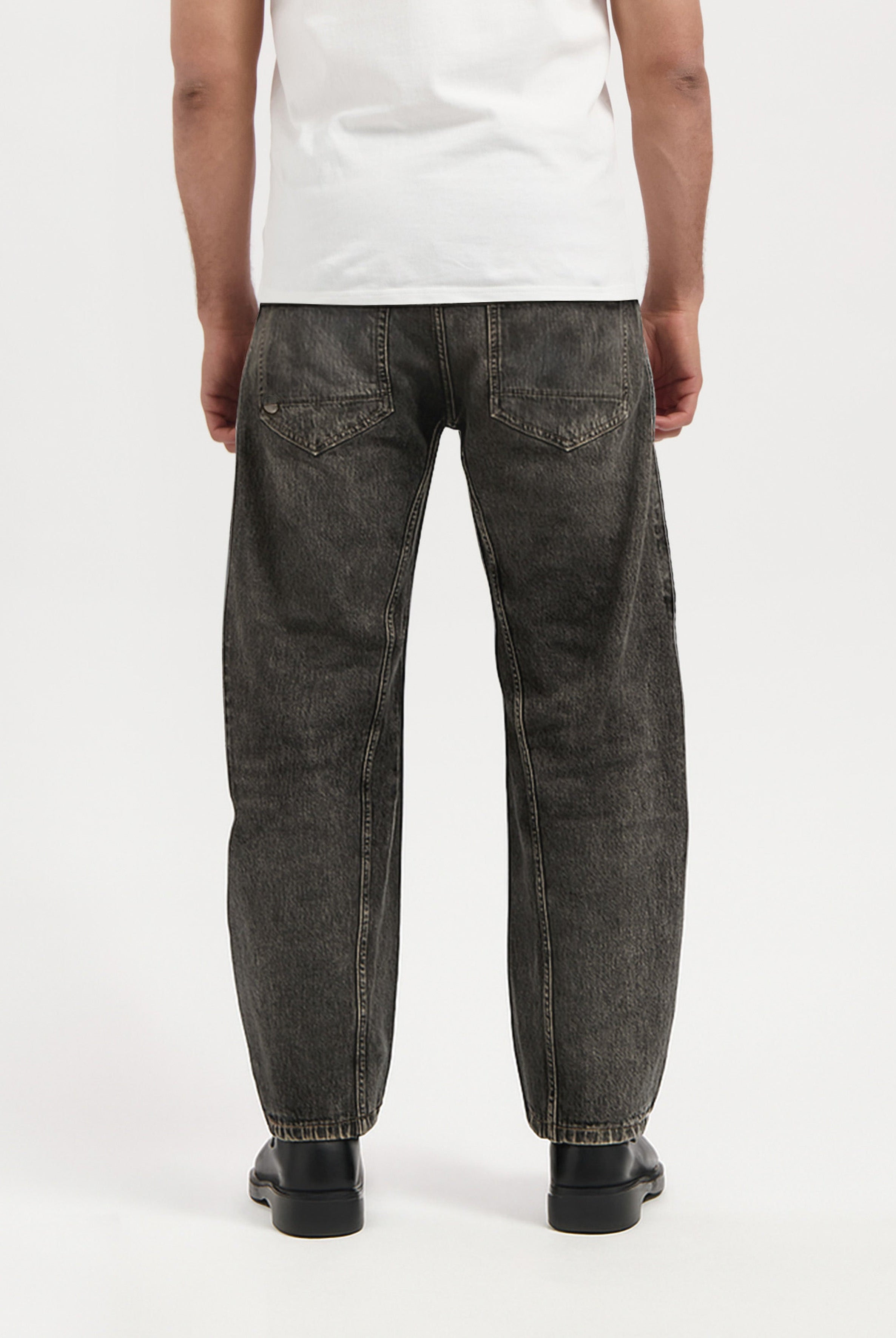 Sustainable MUD Jeans in dark blue denim, showcasing eco-friendly design and slim fit, paired with casual white sneakers.
