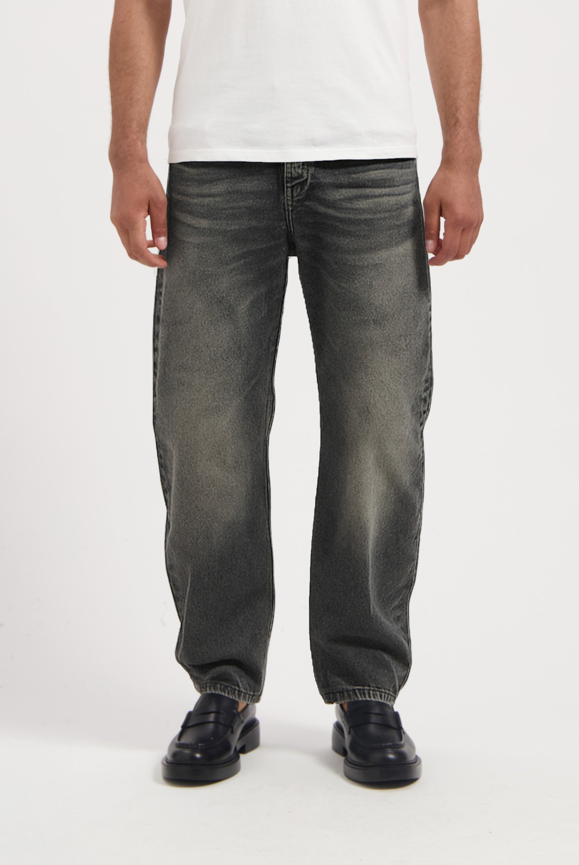 Sustainable MUD Jeans in deep blue denim, crafted from organic cotton, featuring a slim fit, paired with white sneakers.