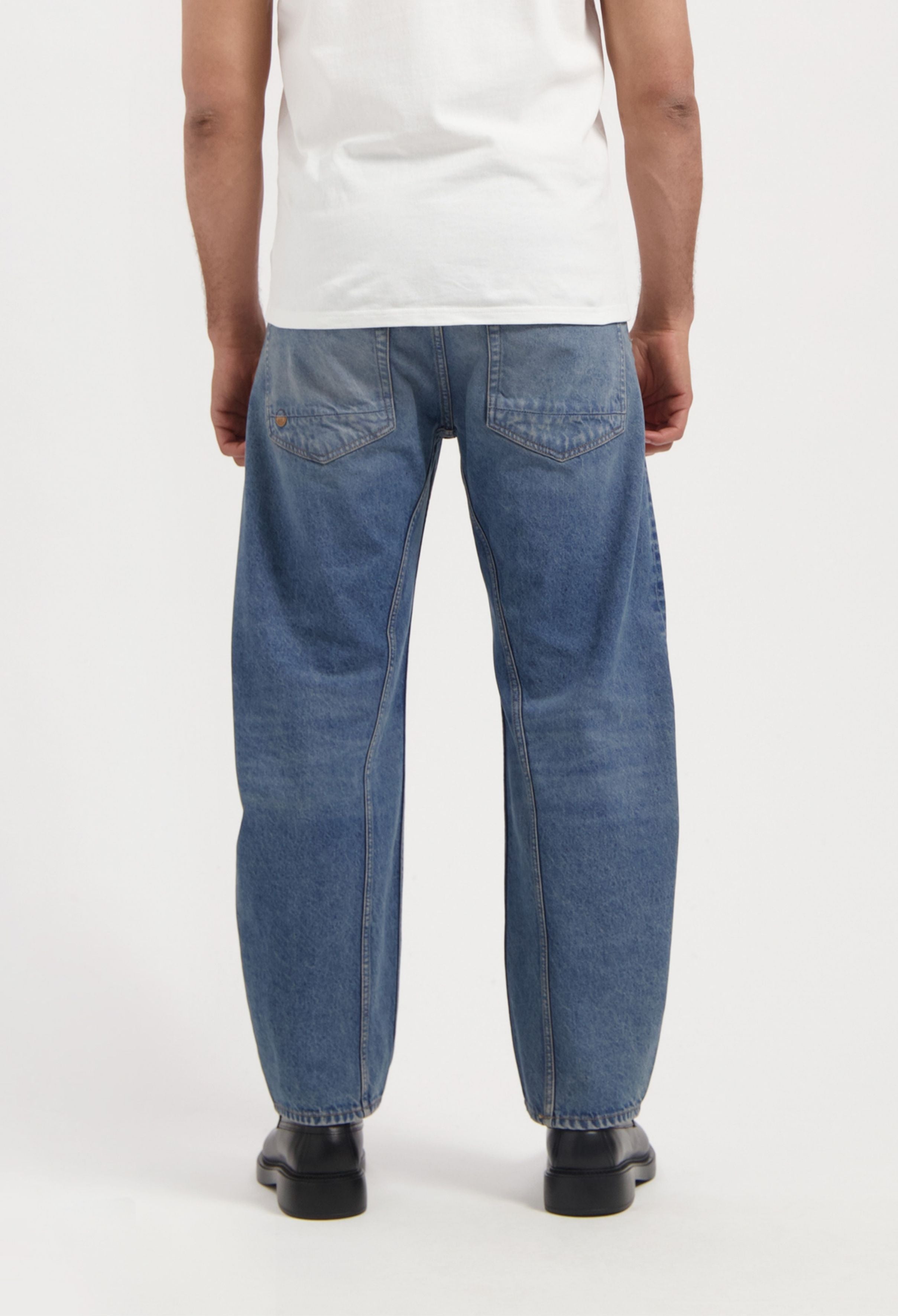 Sustainable MUD Jeans in light blue denim, featuring ethical production, worn with a black t-shirt.