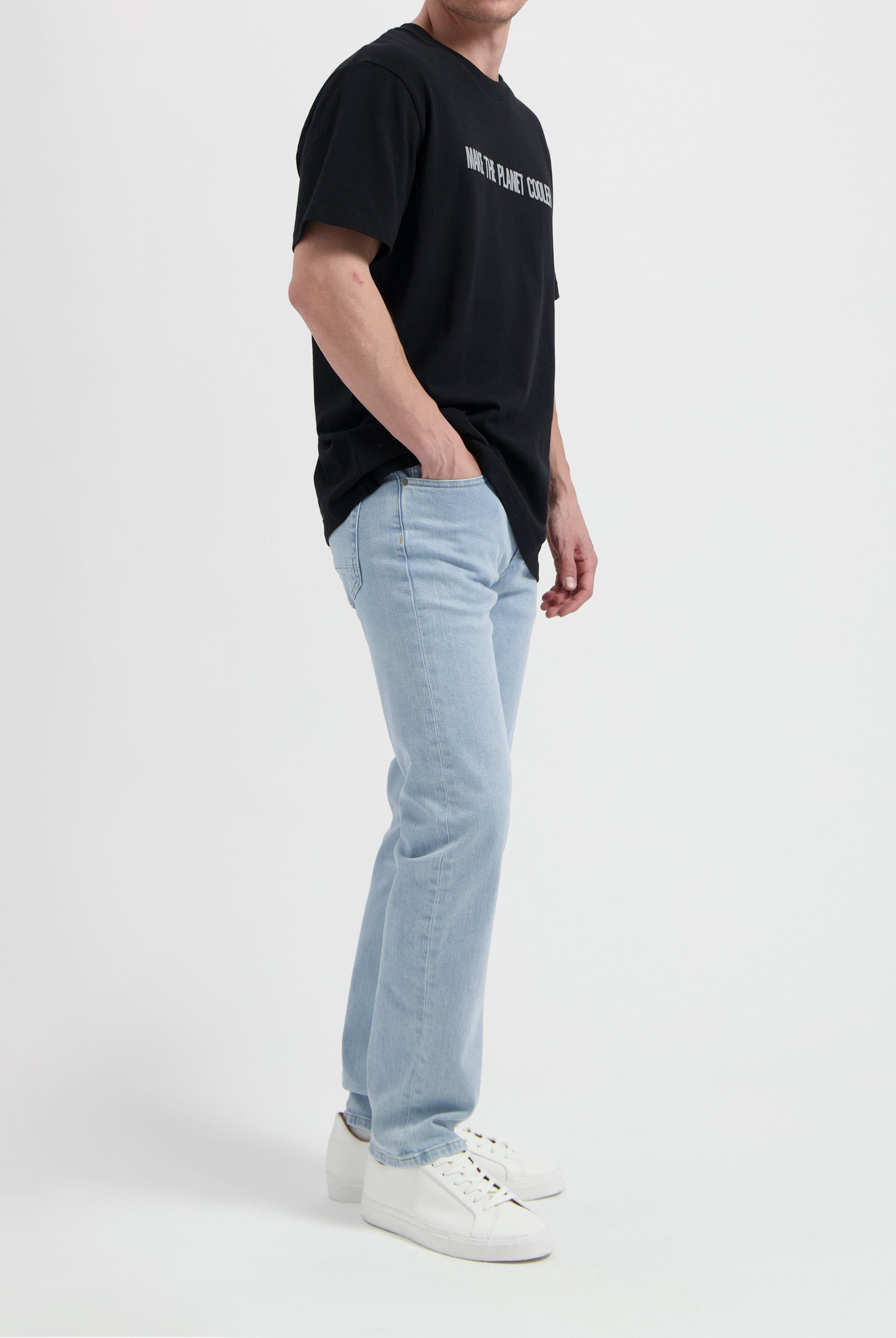Sustainable MUD Jeans in classic blue denim crafted from organic cotton, paired with a casual white T-shirt.
