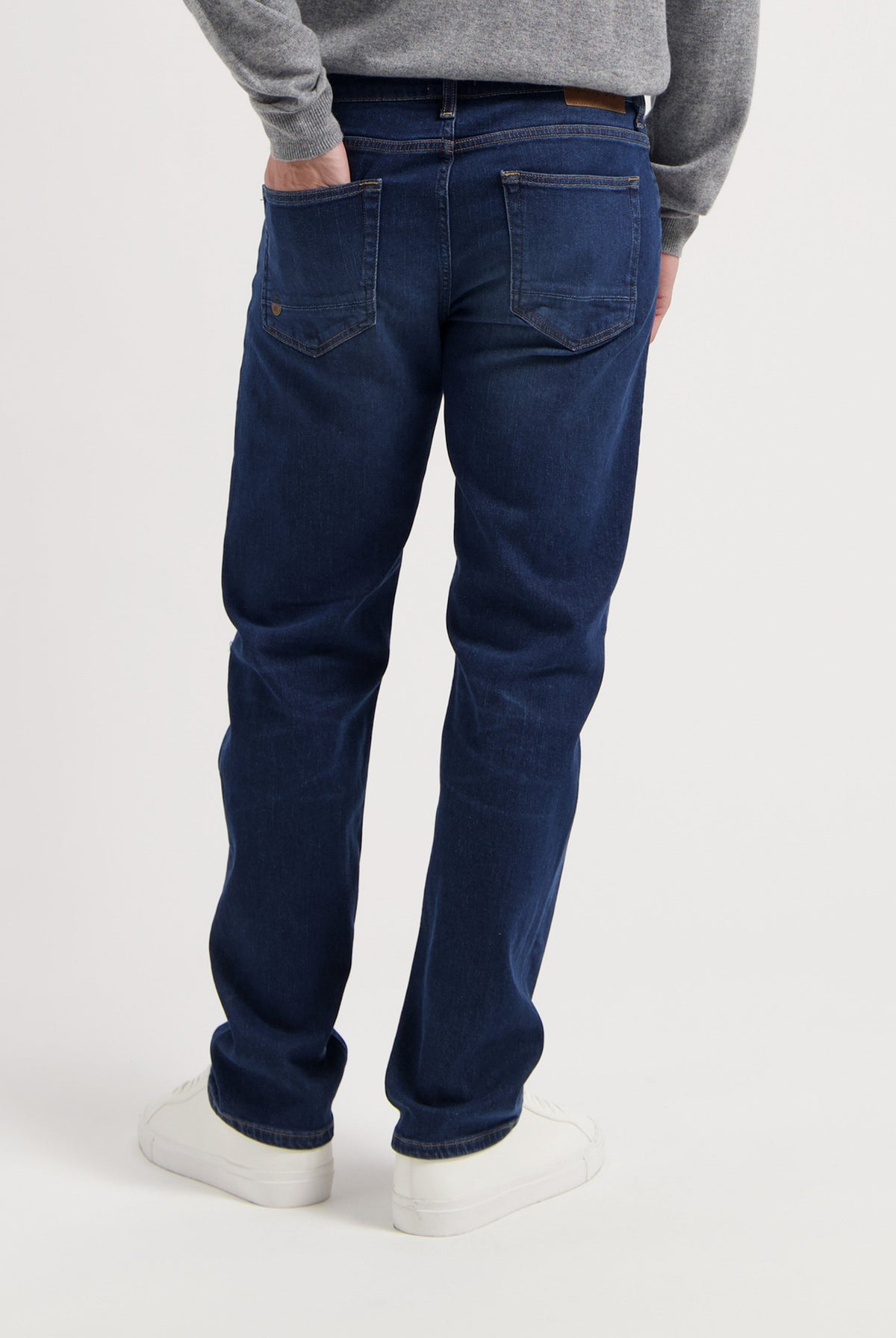 Sustainable MUD Jeans jacket and jeans in light blue denim, crafted from organic cotton, paired with white sneakers.