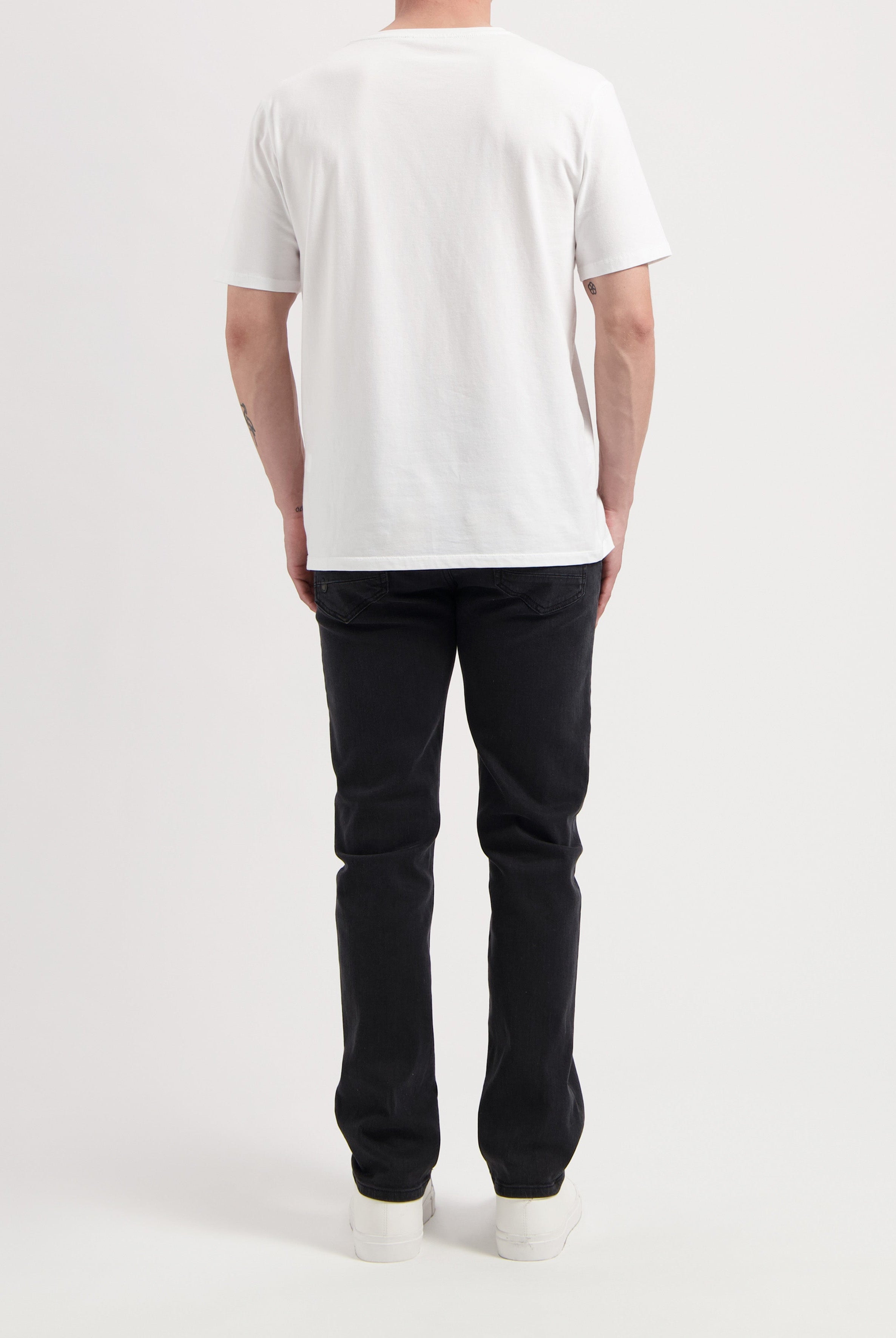 Sustainable MUD Jeans featuring a relaxed fit in classic blue denim, paired with a white t-shirt, promoting ethical fashion.