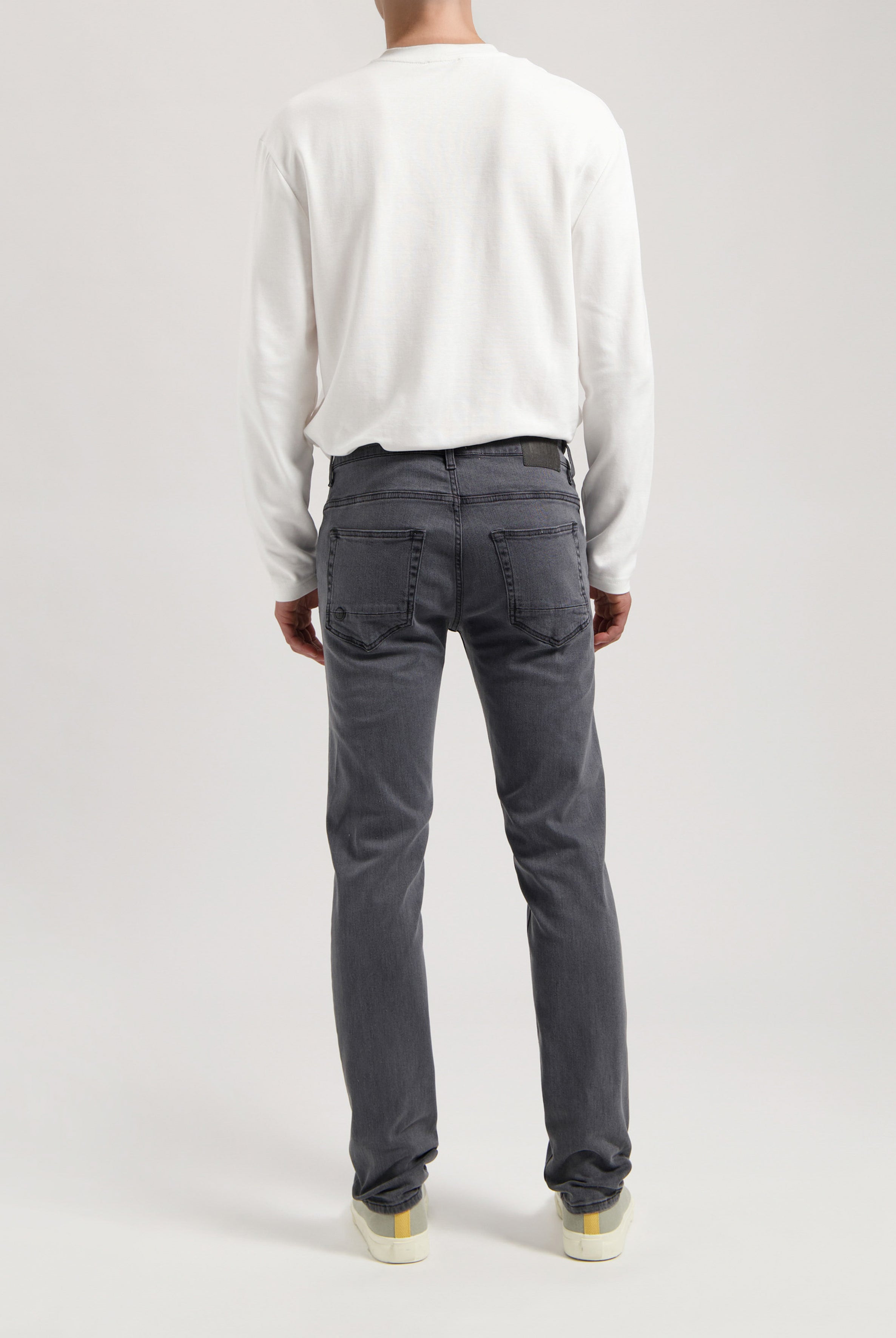 Sustainable MUD Jeans made from ethical materials, featuring classic blue denim, paired with a simple white tee.
