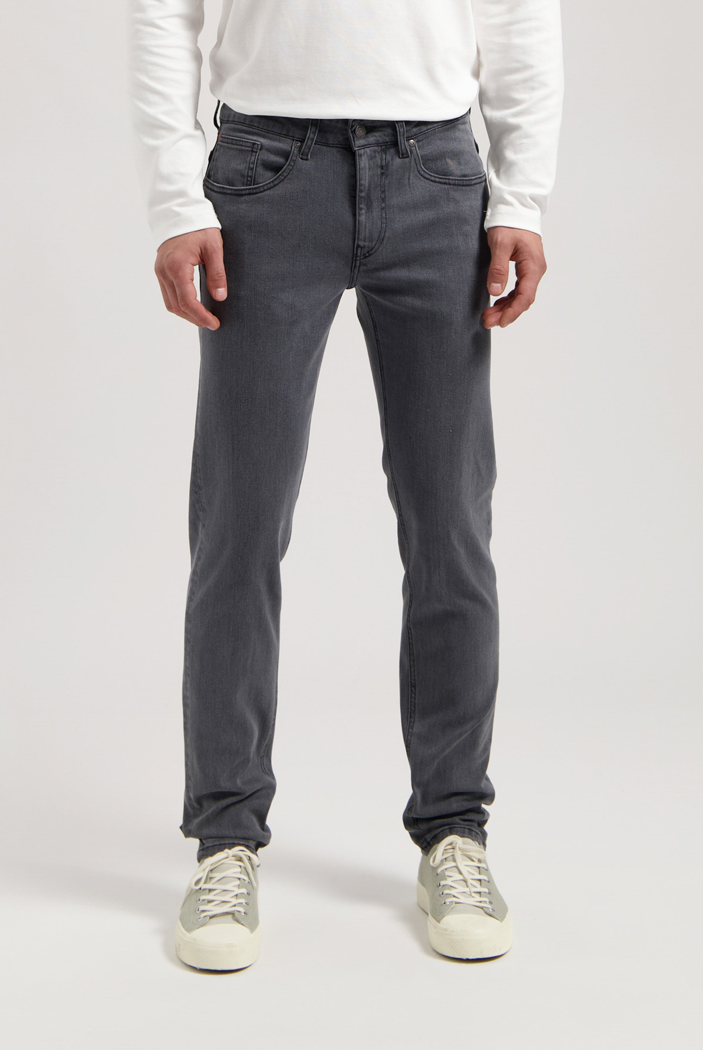 Sustainable MUD Jeans in blue denim, classic fit, crafted with ethical practices, paired with a white casual shirt.
