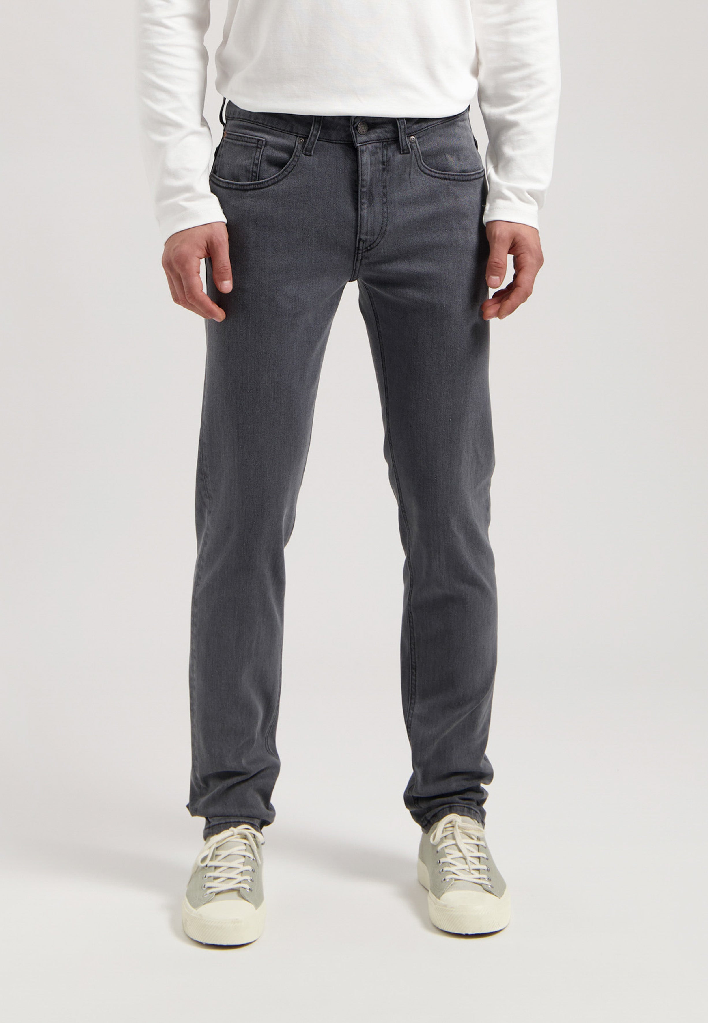 Sustainable MUD Jeans in blue denim, classic fit, crafted with ethical practices, paired with a white casual shirt.