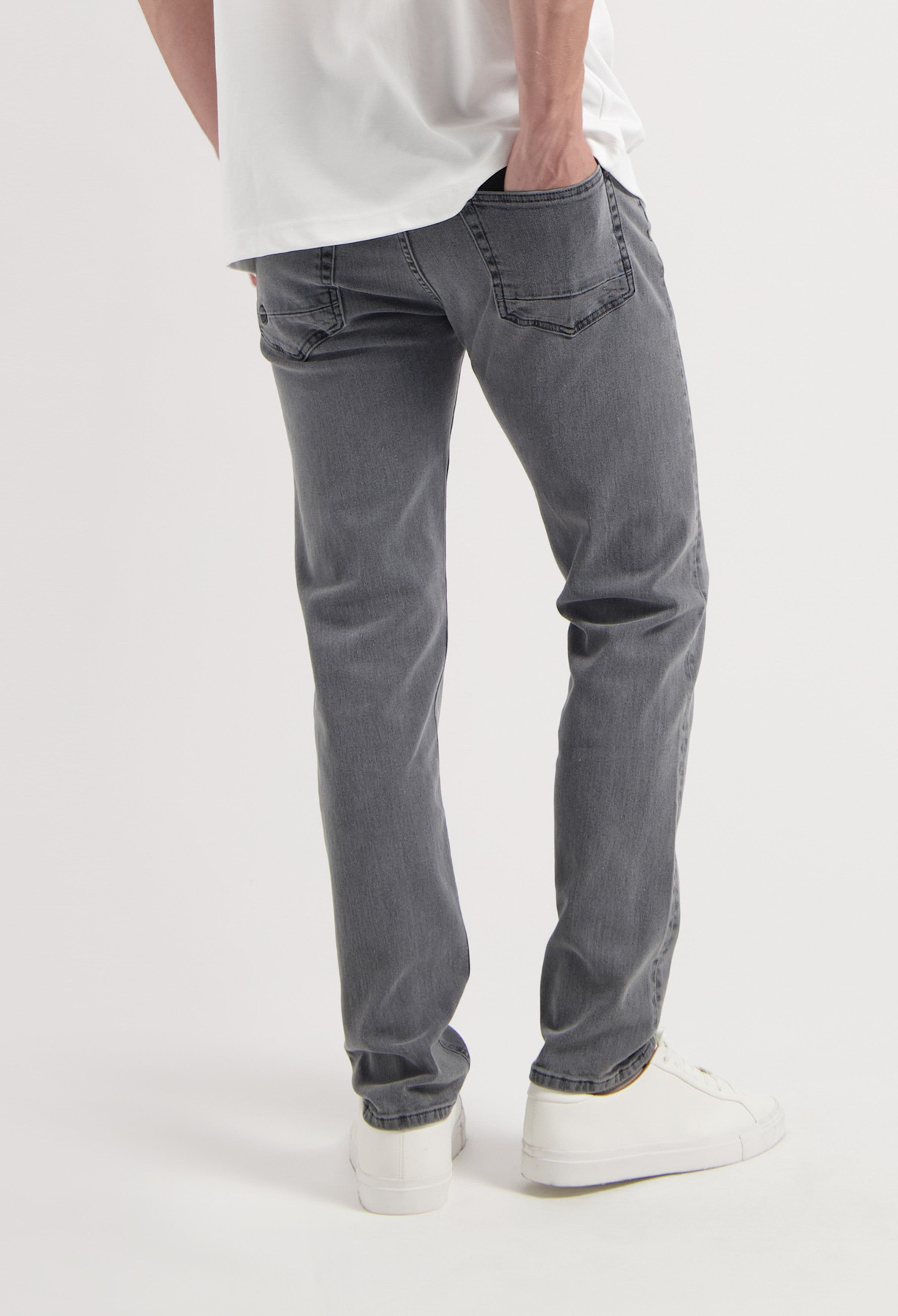 Sustainable MUD Jeans made from organic cotton, featuring gray denim in a slim fit, paired with a black sweater.