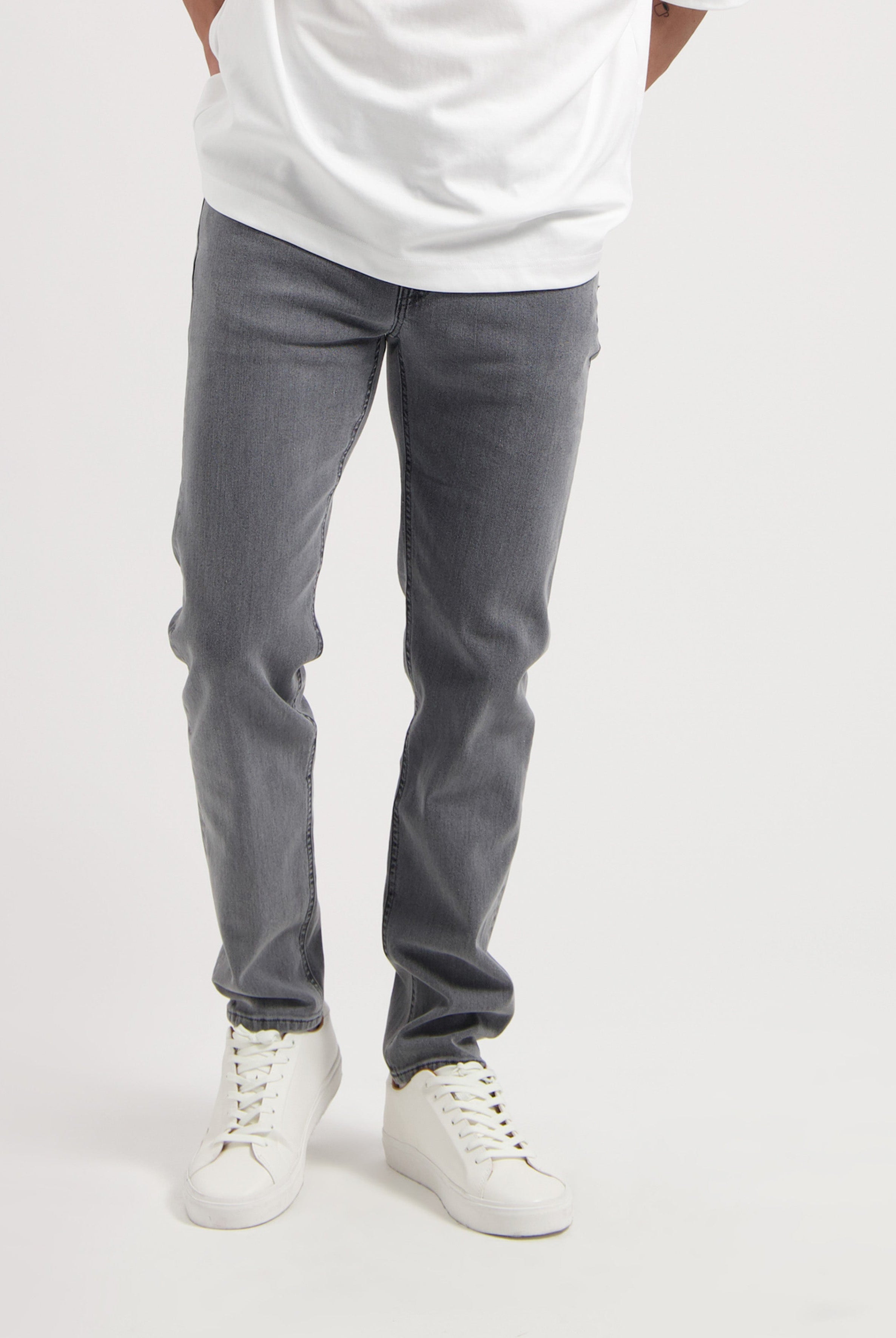 Sustainable MUD Jeans in gray denim, showcasing eco-friendly design and ethical production, paired with white sneakers.
