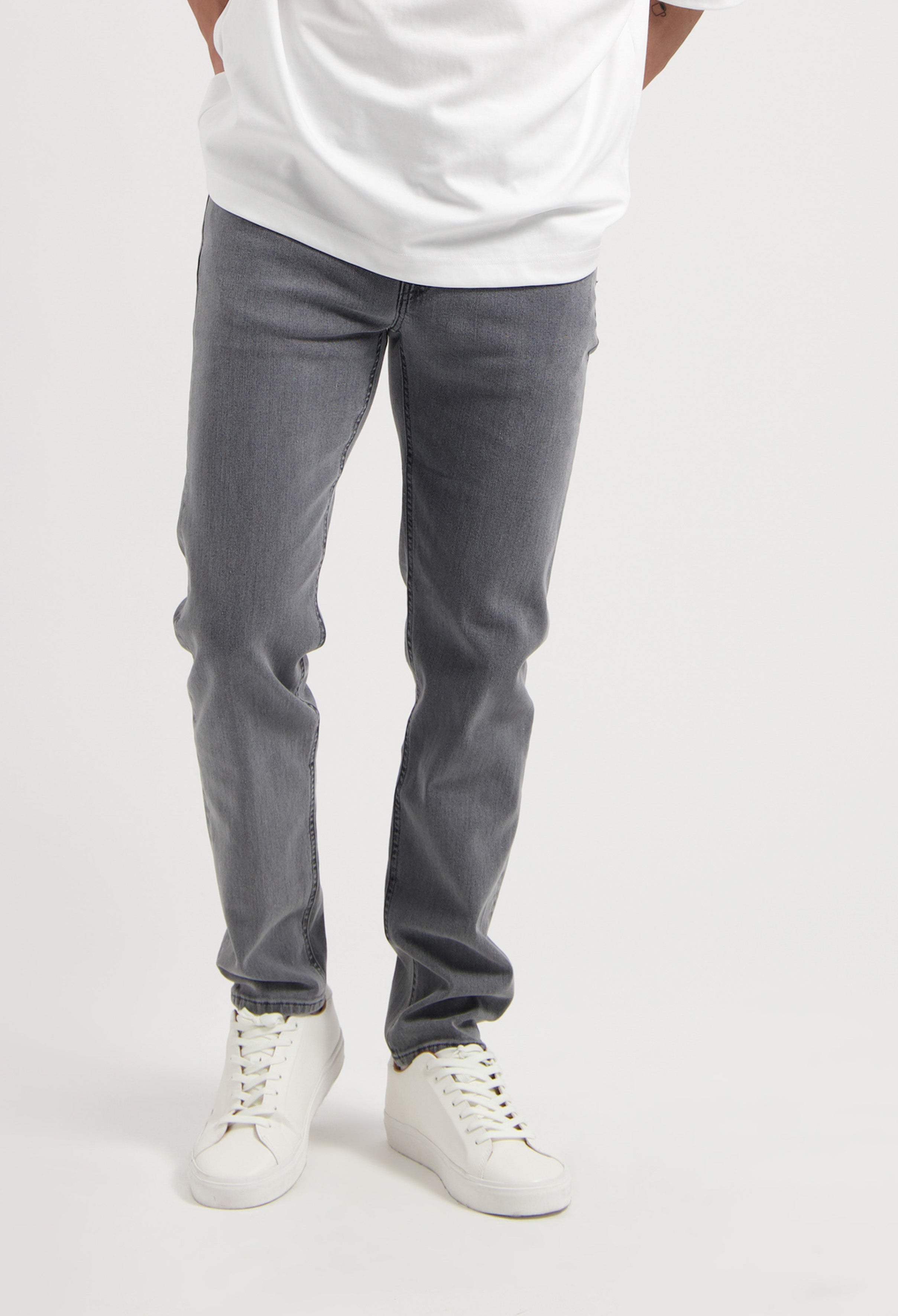 Sustainable MUD Jeans in gray denim, showcasing eco-friendly design and ethical production, paired with white sneakers.