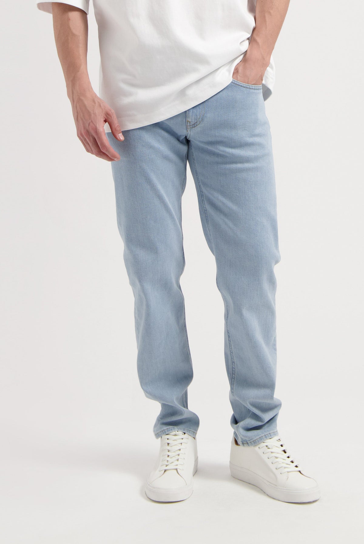 Sustainable MUD Jeans in black denim, ethical style with tapered fit, paired with a simple black t-shirt for a minimalist look.
