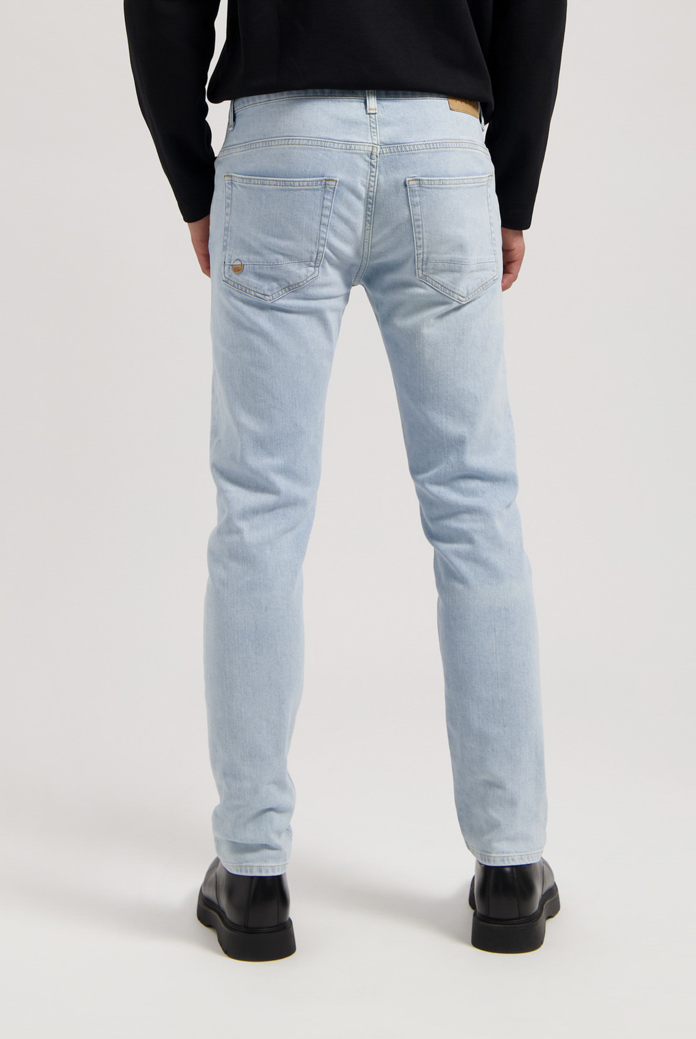 Sustainable MUD Jeans in light blue organic cotton denim, showcasing a classic fit with ethical craftsmanship.