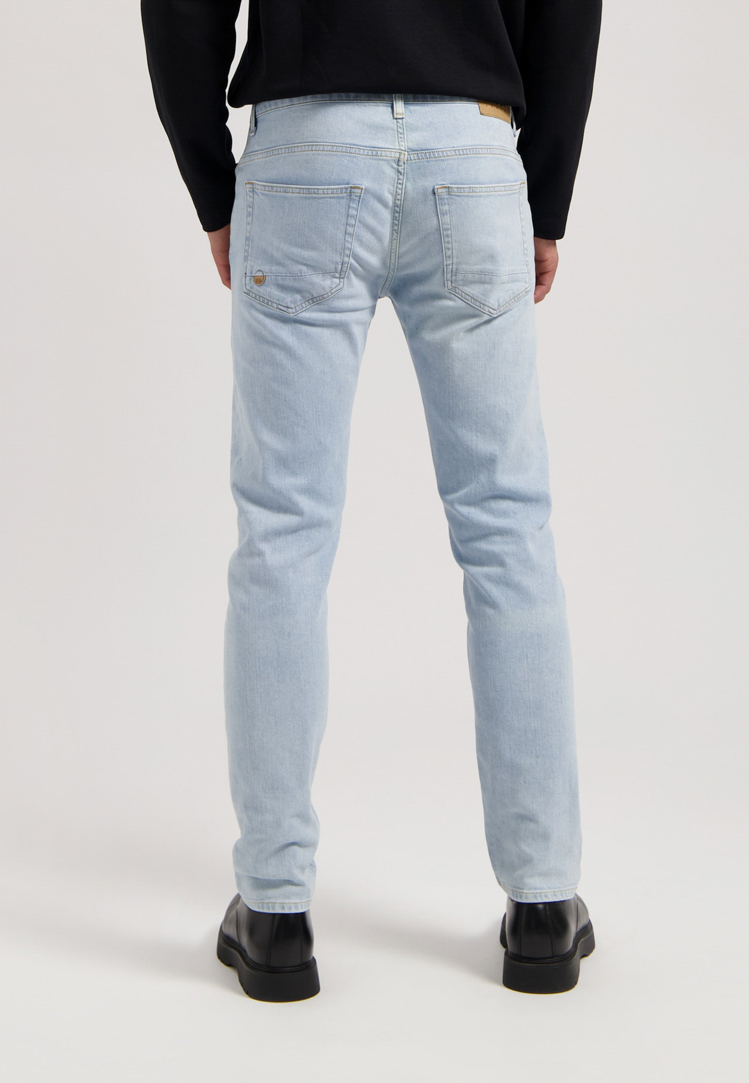 Sustainable MUD Jeans in light blue organic cotton denim, showcasing a classic fit with ethical craftsmanship.