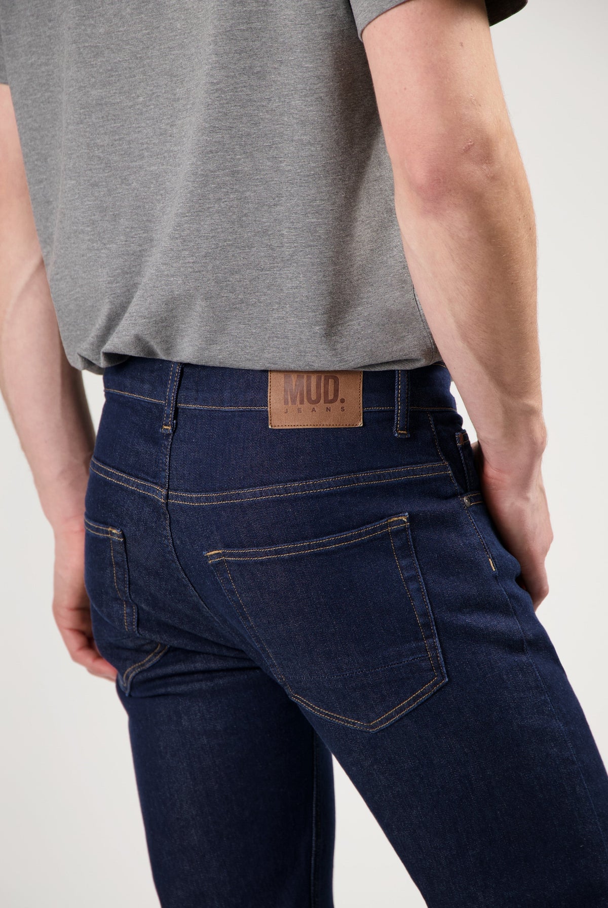 Mud Jeans sustainable light blue denim, crafted ethically from organic cotton, paired with a simple white long-sleeve shirt.