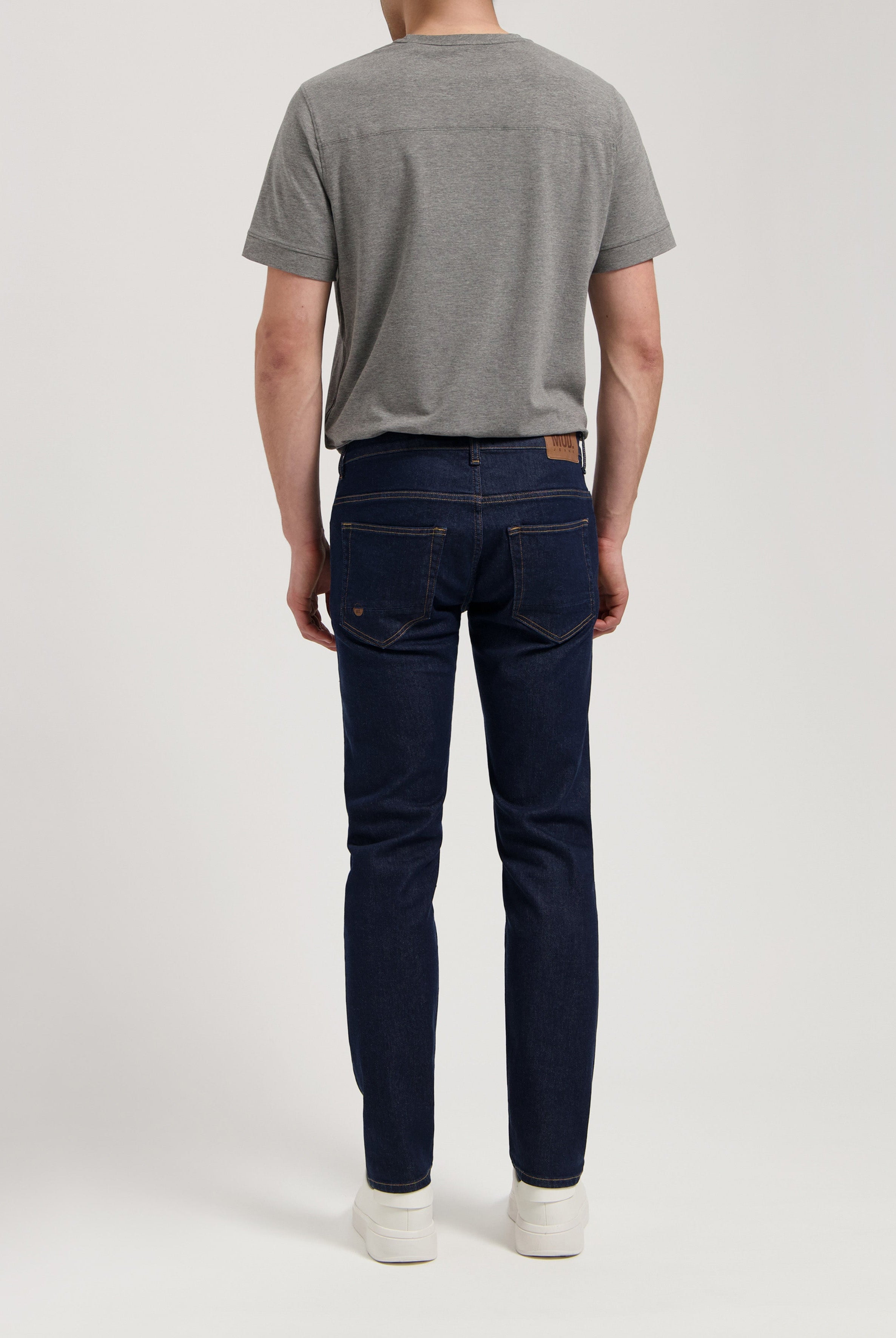 Sustainable MUD Jeans made from organic cotton, styled with a gray sweater, offering a timeless and ethical fashion choice.