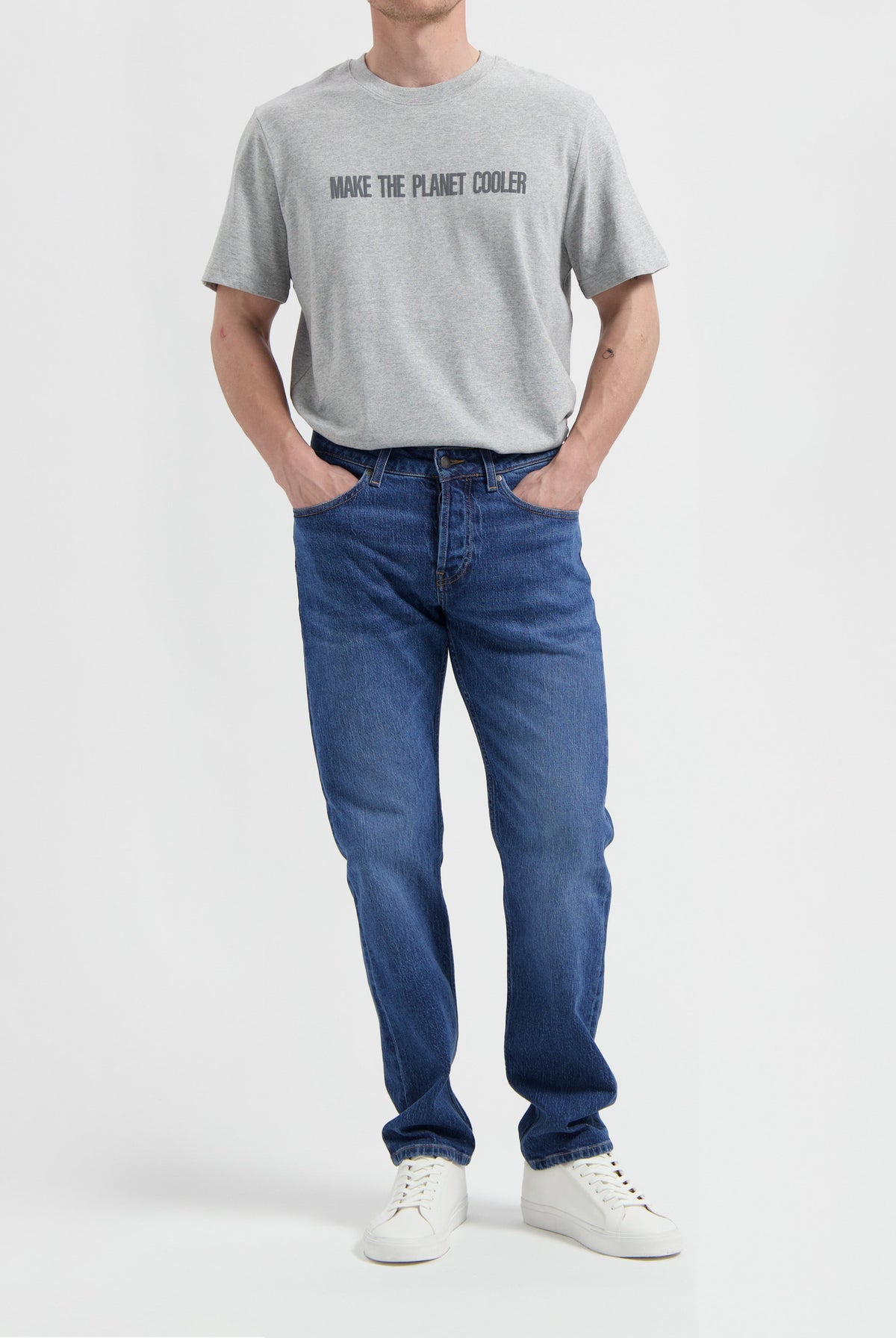 Sustainable MUD Jeans in deep indigo, crafted from ethical cotton, featuring a classic fit, paired with a gray sweater.
