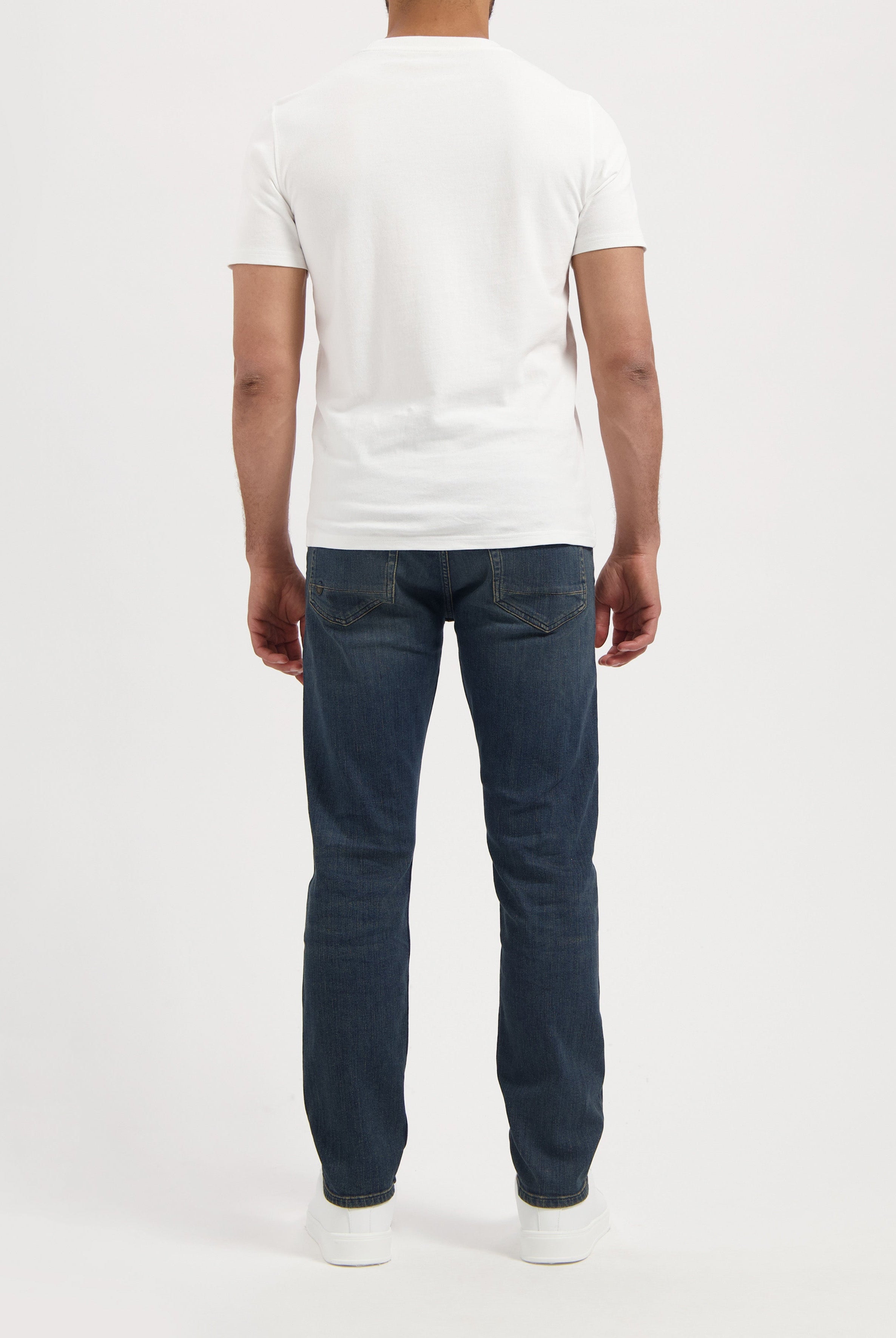 Sustainable MUD Jeans in light blue denim, classic fit, paired with a black t-shirt. Eco-friendly fashion choice.
