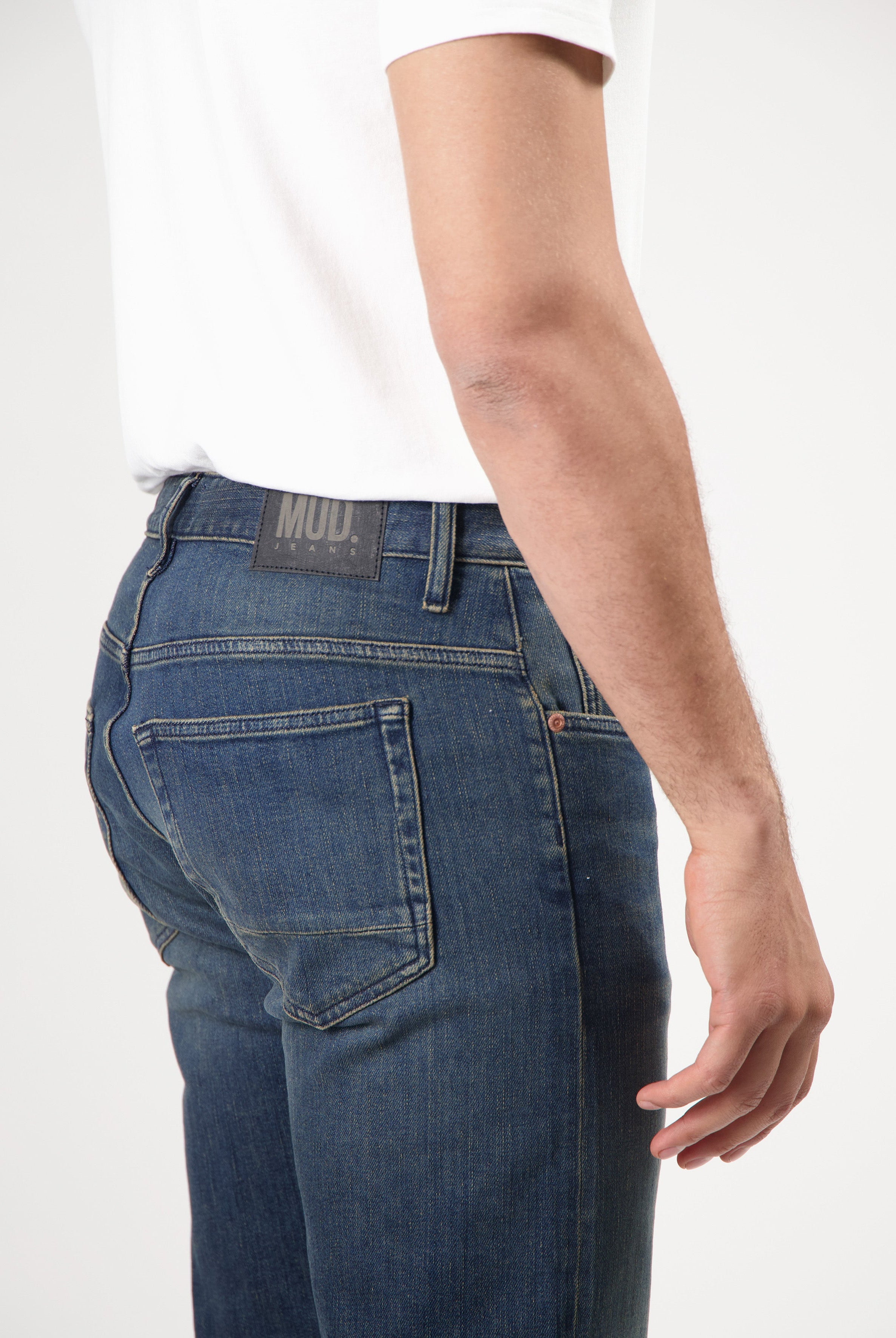 Sustainable MUD Jeans in light blue, crafted from organic cotton, featuring a classic fit, paired with black shoes.