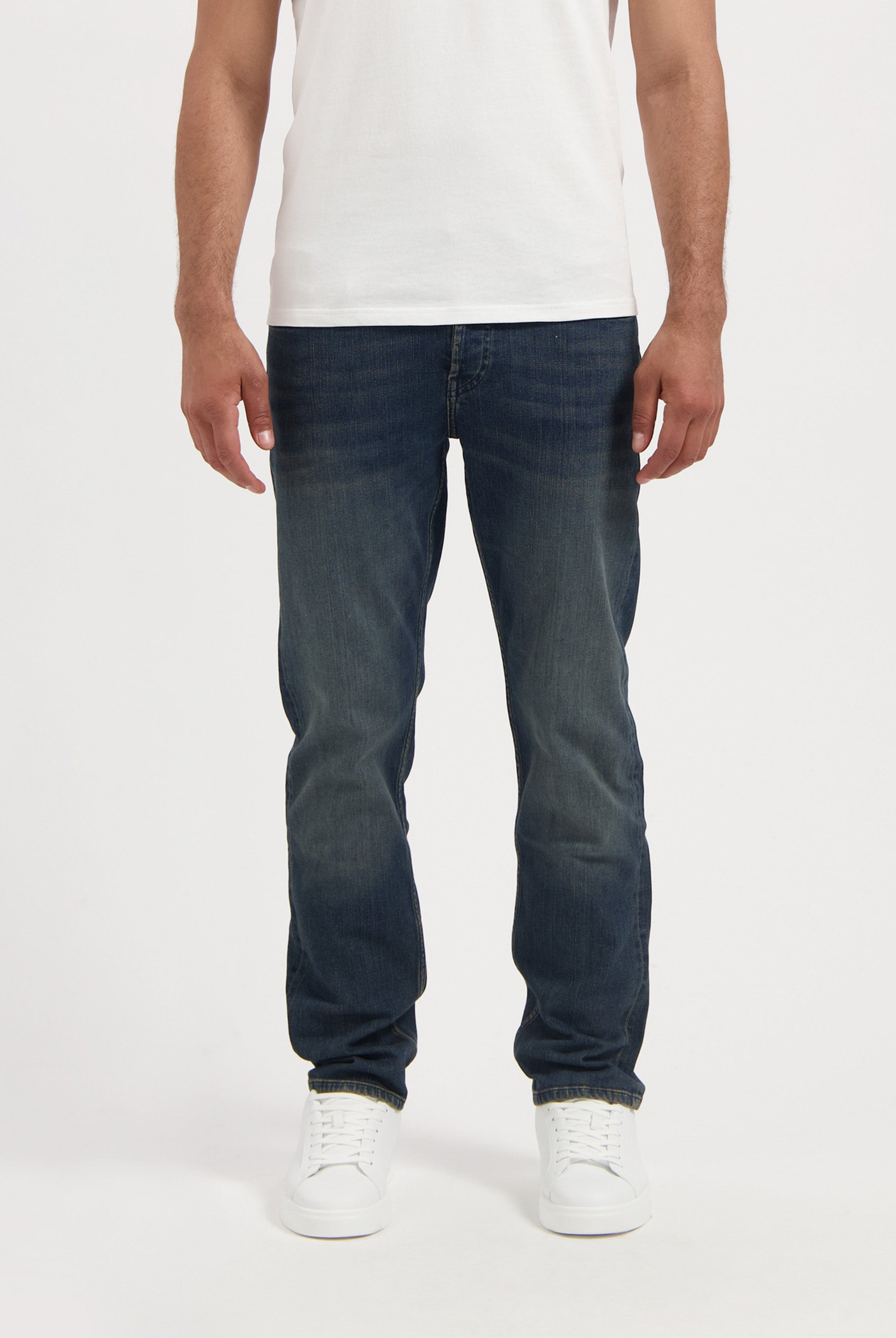 Sustainable MUD Jeans in light blue denim, crafted ethically from organic cotton, shown with black t-shirt and shoes.